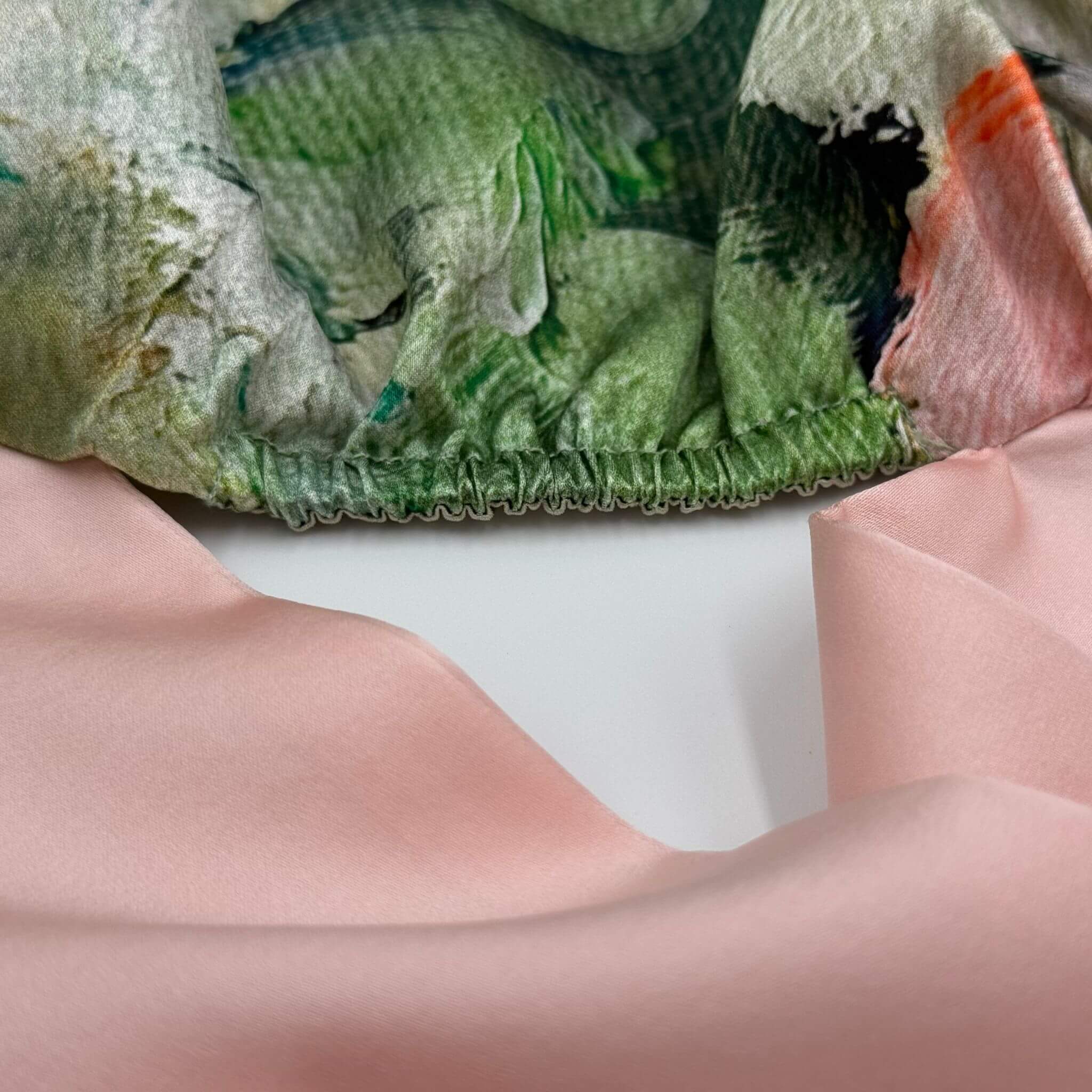Close-up of a green textured silk fabric for bonnet with a white background