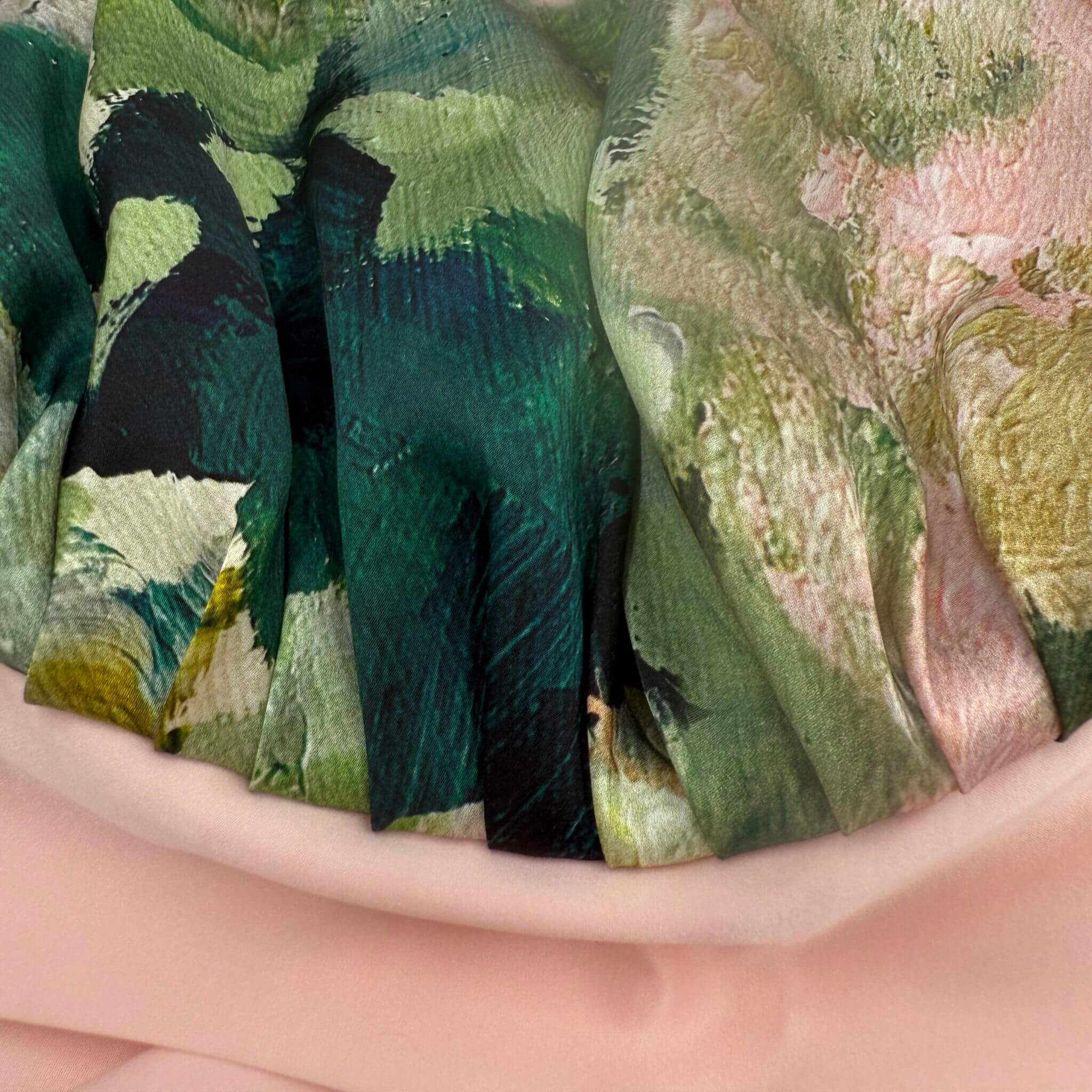 Close-up of a silk fabric for bonnet with green and black abstract pattern