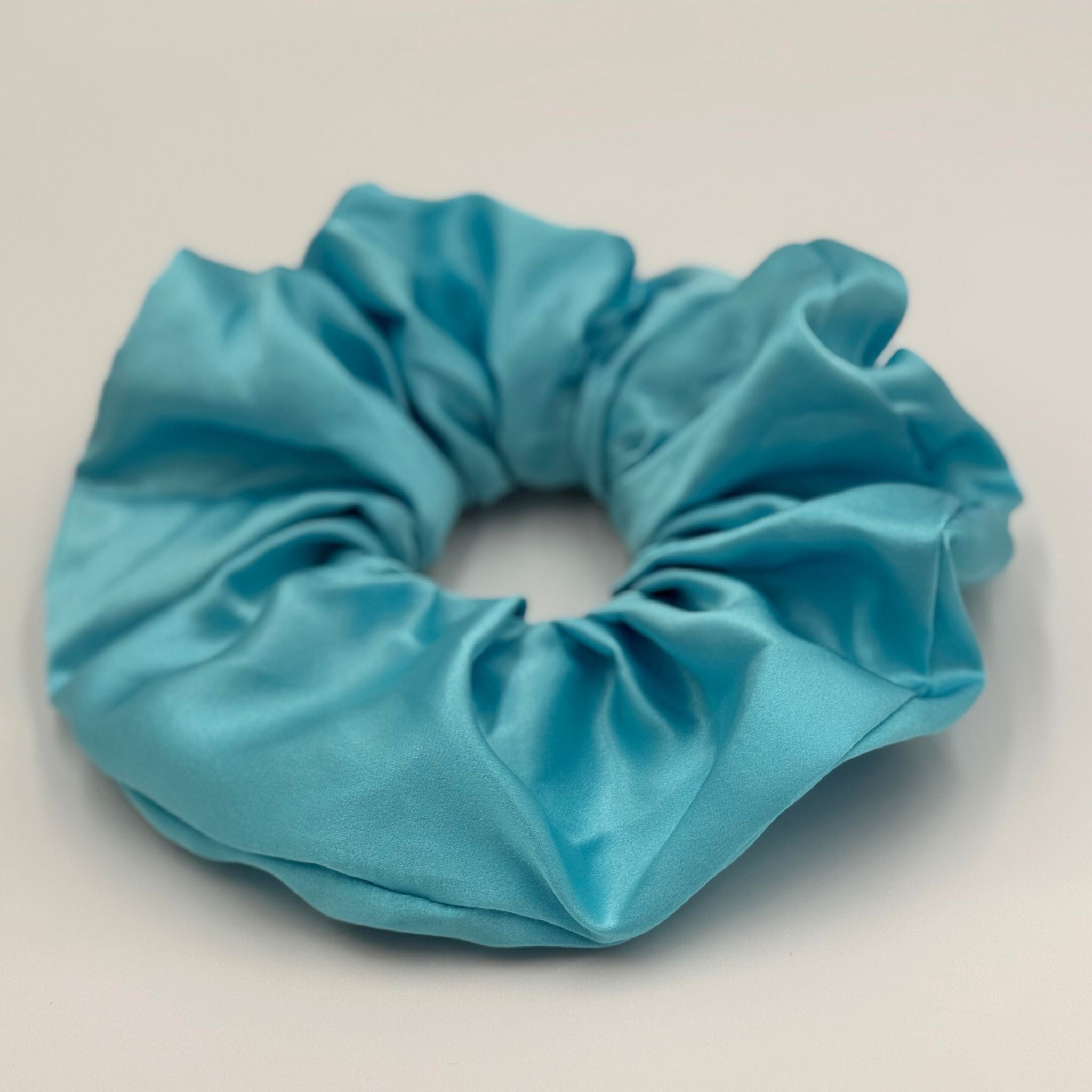 Light Blue silk scrunchie on a light gray background
