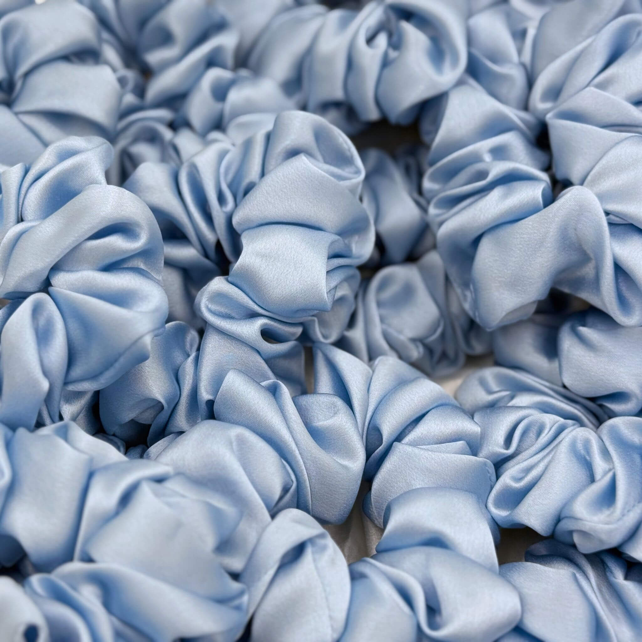 baby blue silk scrunchies in a pile