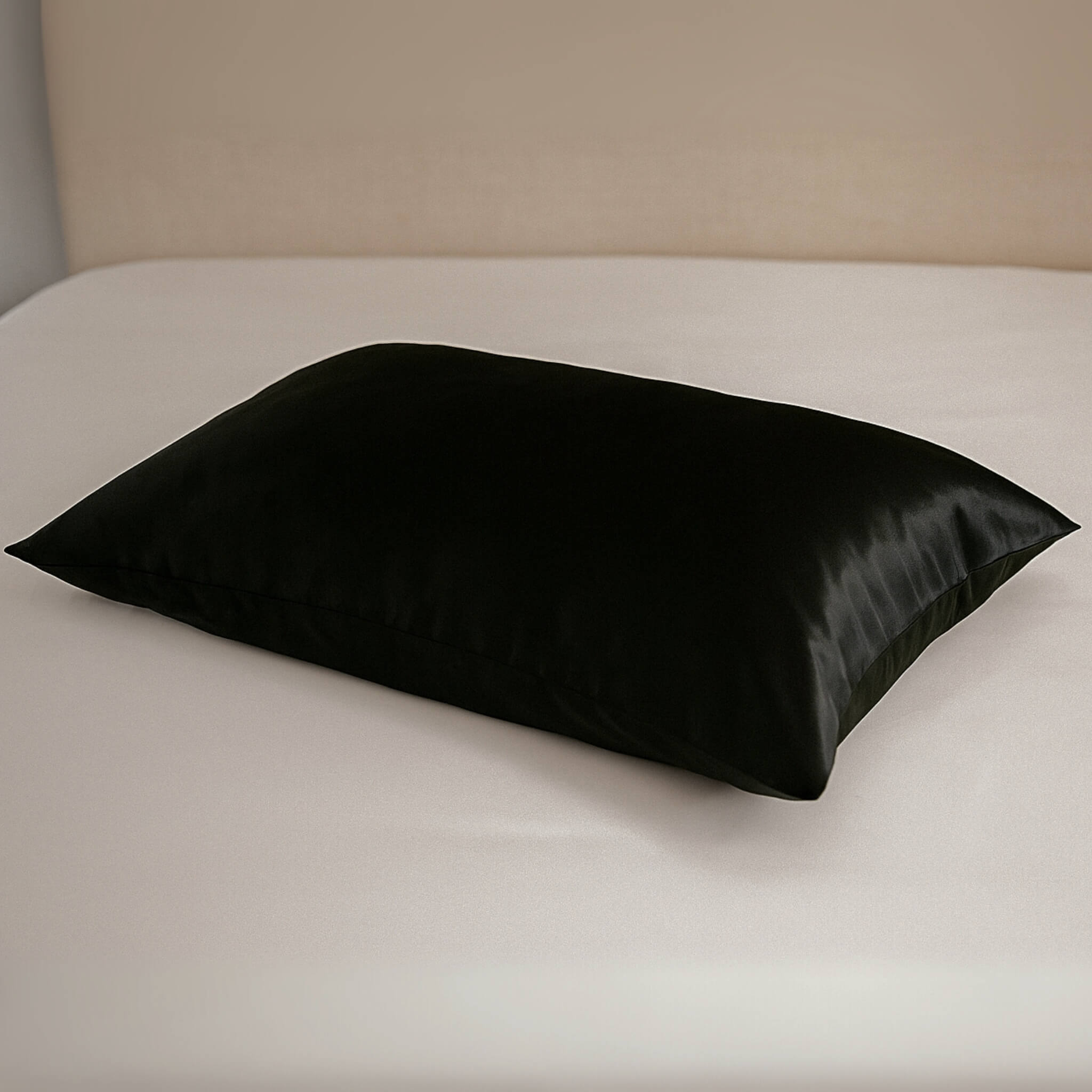 Black silk pillow on a white bed