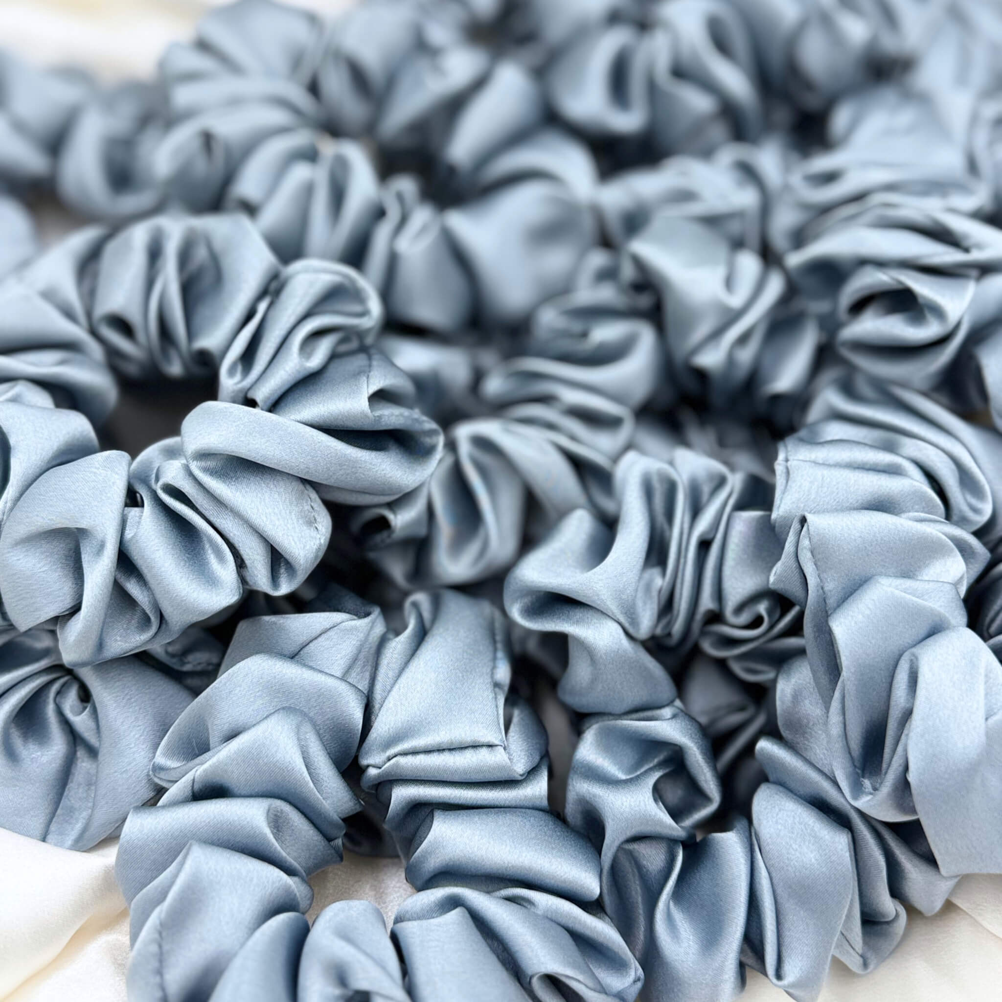 dusty blue silk scrunchies in a pile