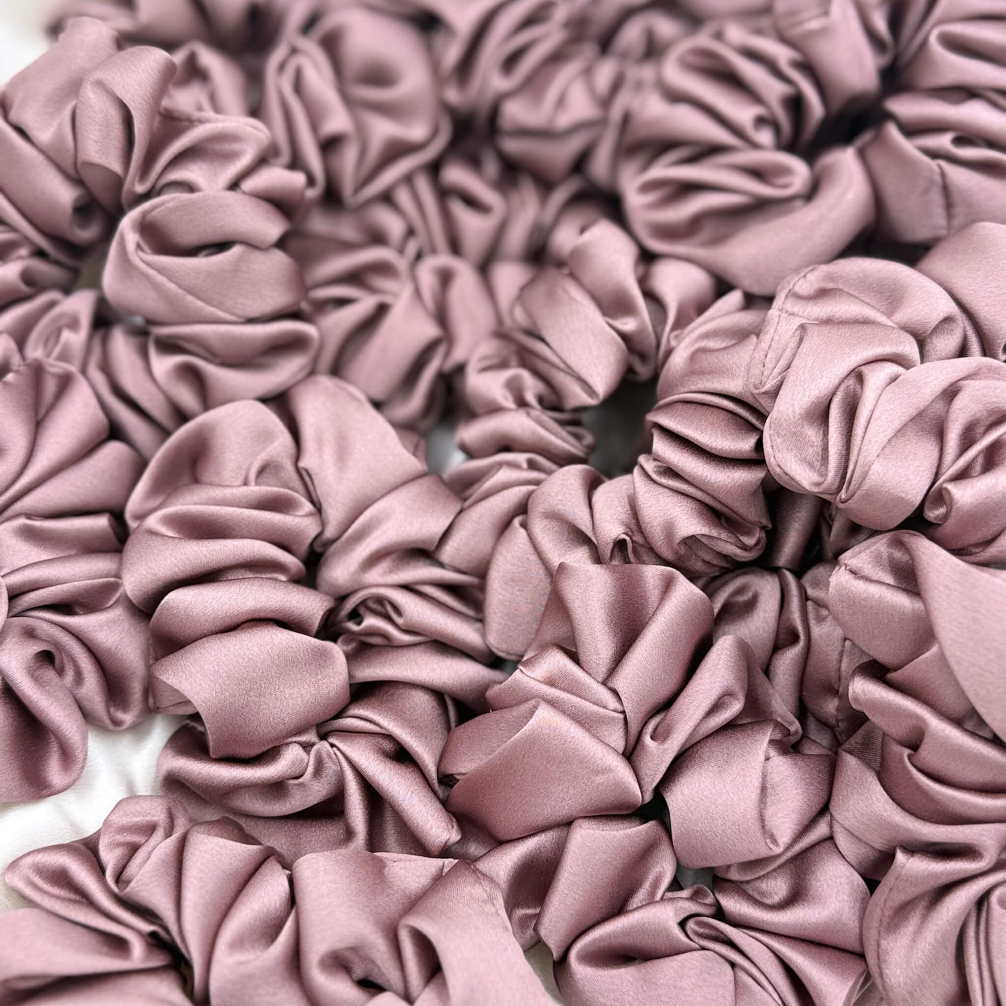 dusty pink silk scrunchies in a pile