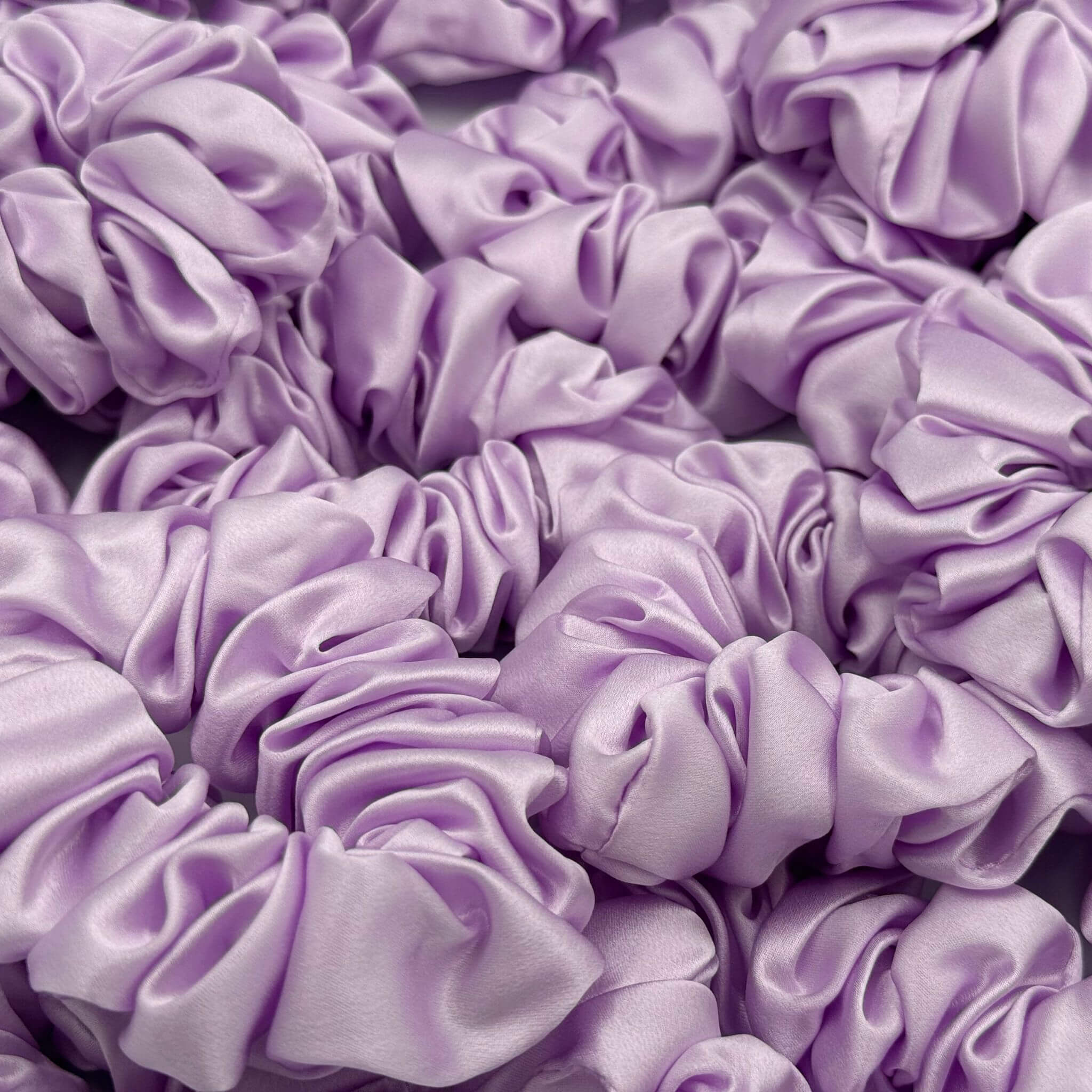 Close-up of multiple purple silk scrunchies.