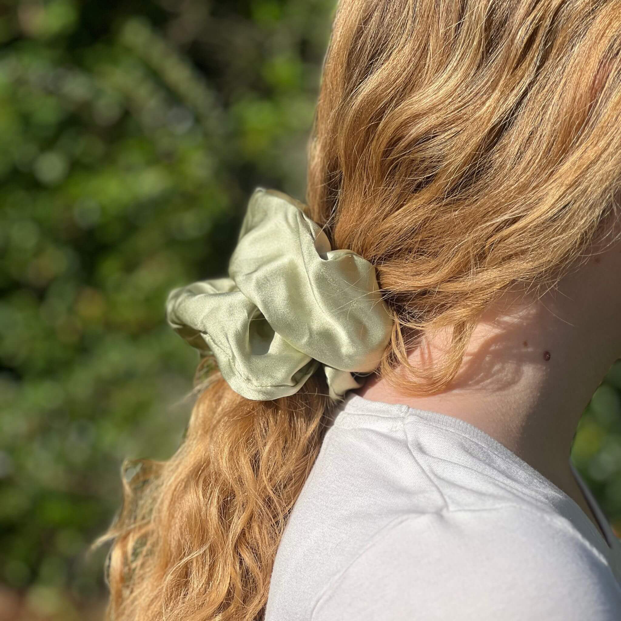 pistachio green oversized silk scrunchie in a low ponytail