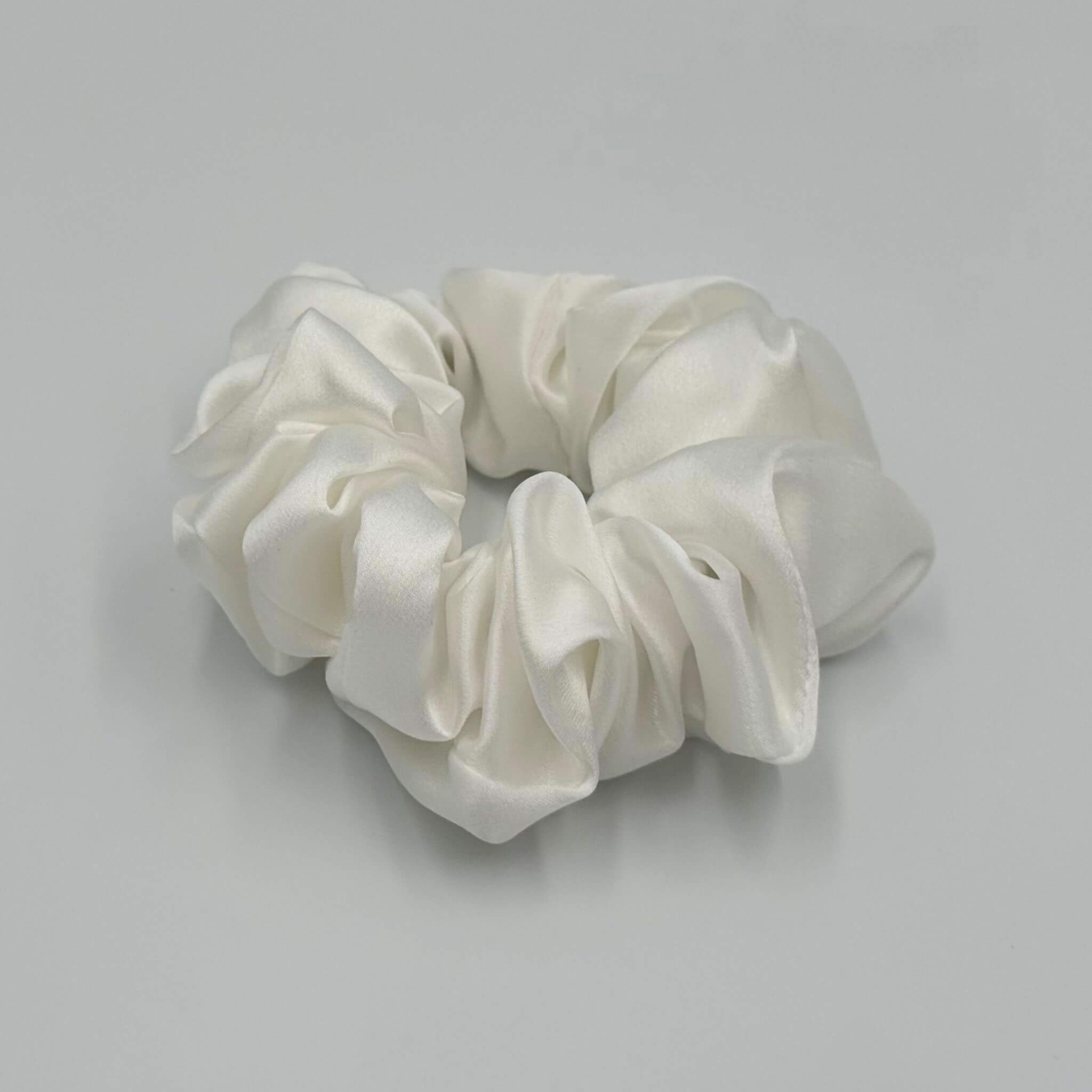 White silk scrunchie on a light gray background