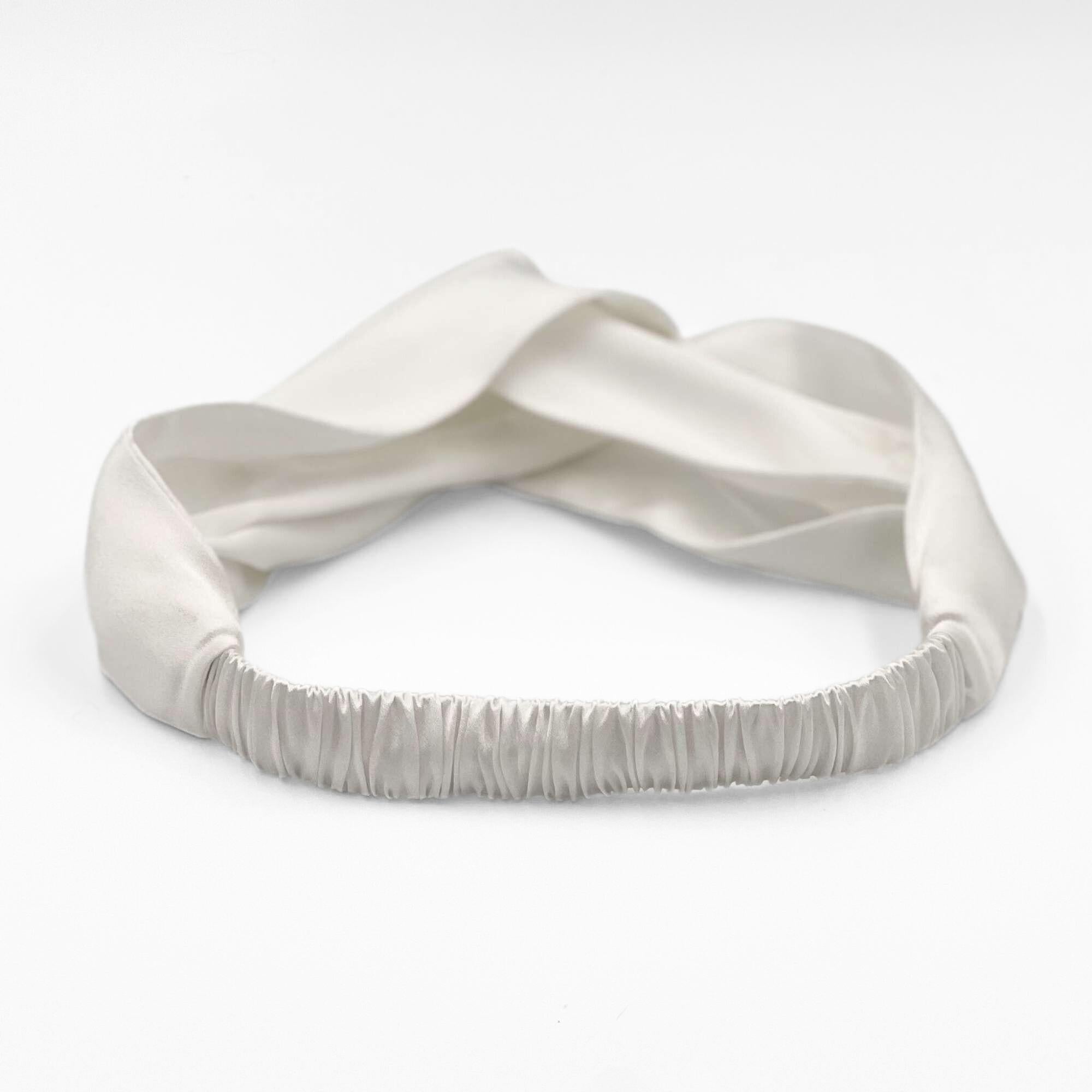 the elasticated back of the ivory white mulberry silk headband on a white background