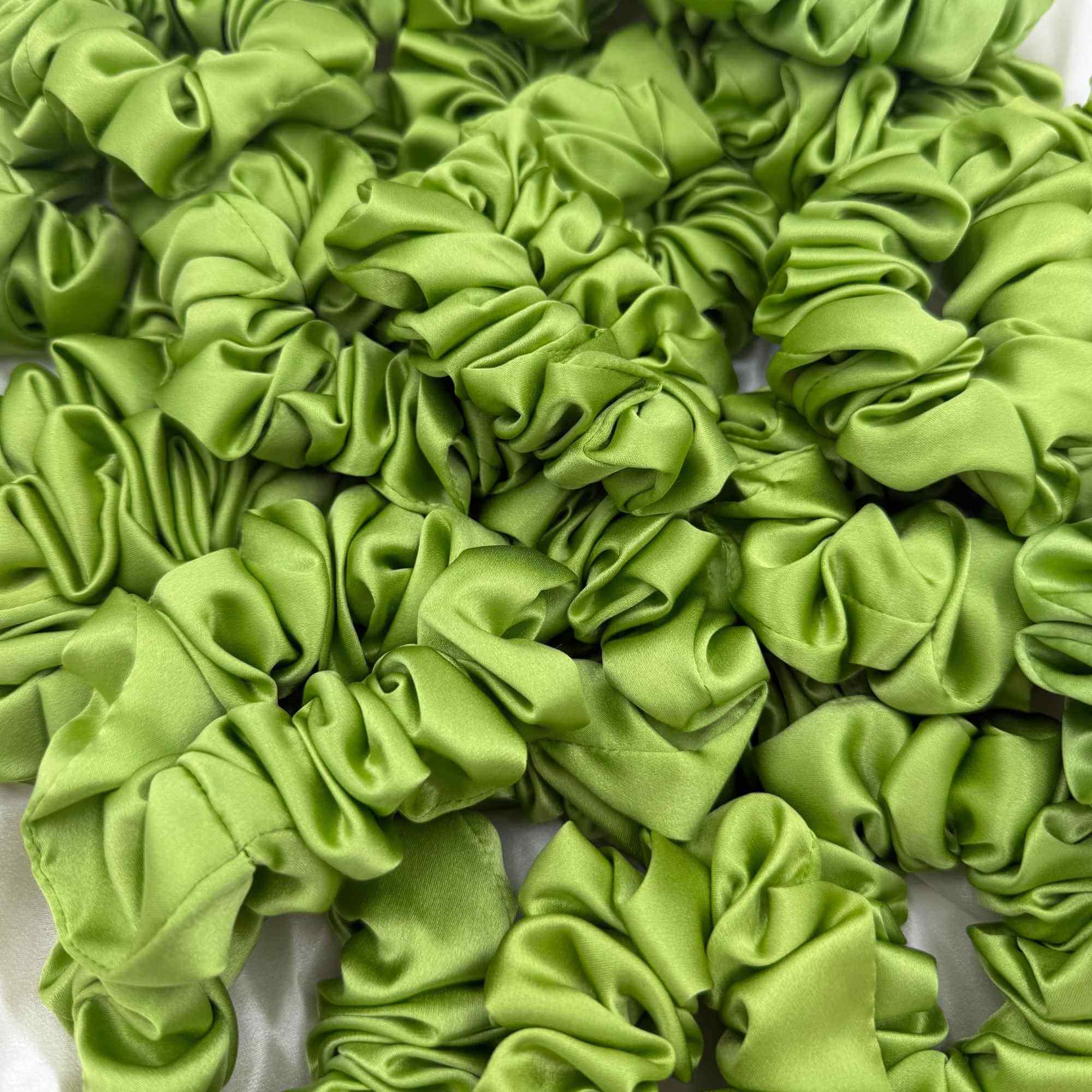 Multiple lime green mulberry silk scrunchies stacked together