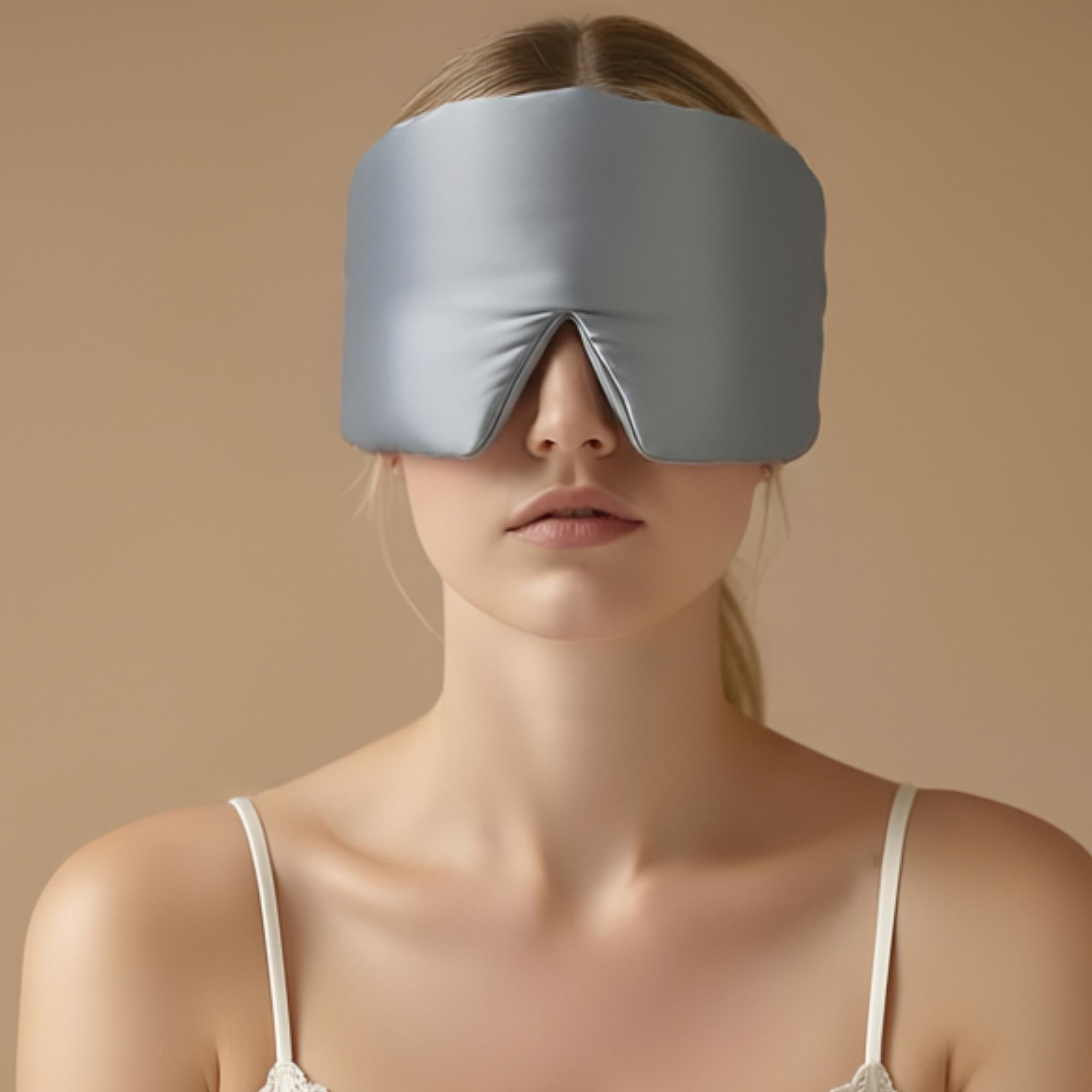 Woman wearing a pale blue mulberry silk sleep mask against a beige background
