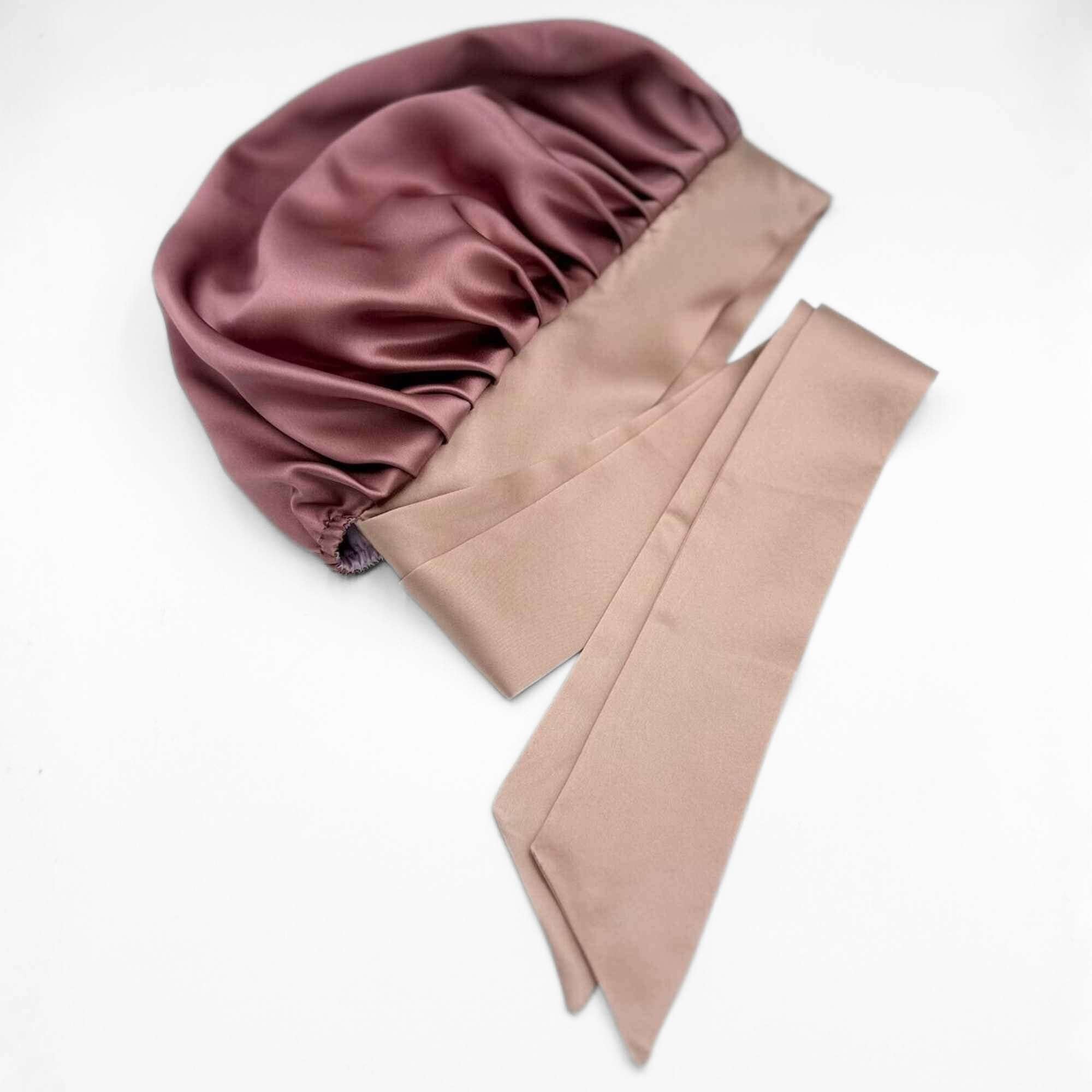 Pink mulberry silk bonnet with a matching pink silk tie on a white background