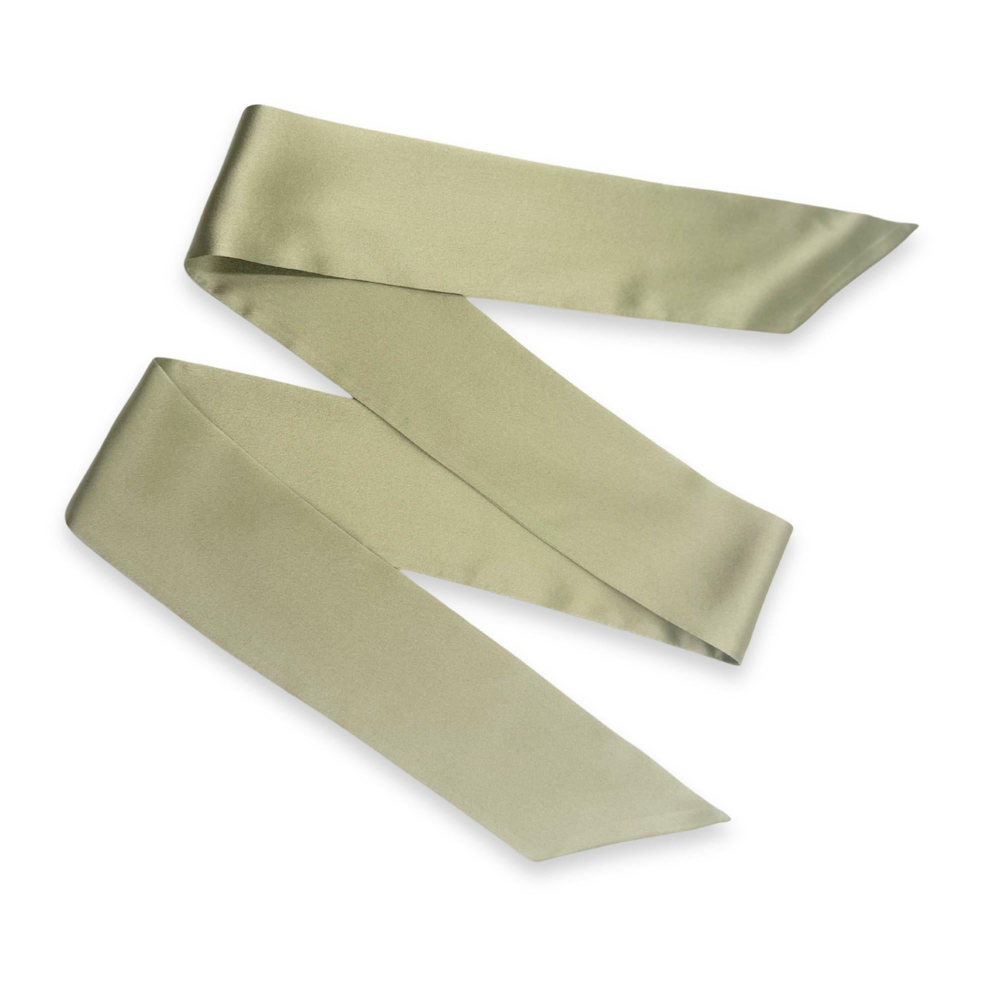 a sage green silk skinny scarf on a white background