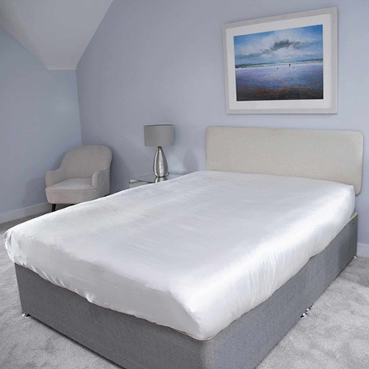 fitted silk sheet on a bed taken from a corner angle