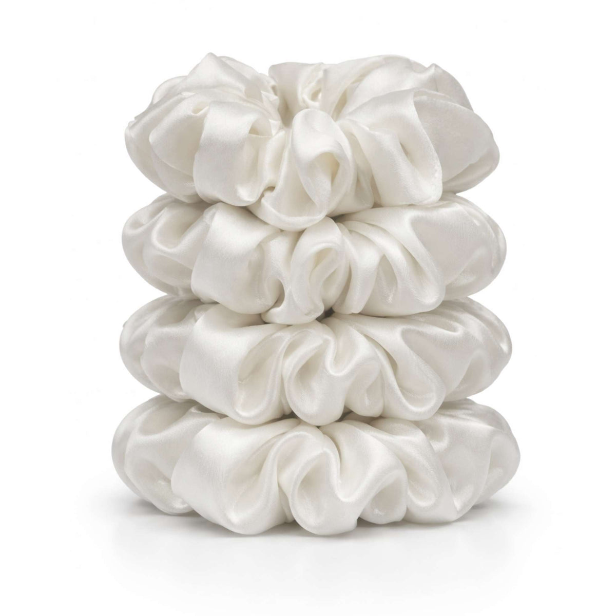 Stack of ivory white silk scrunchies on a white background