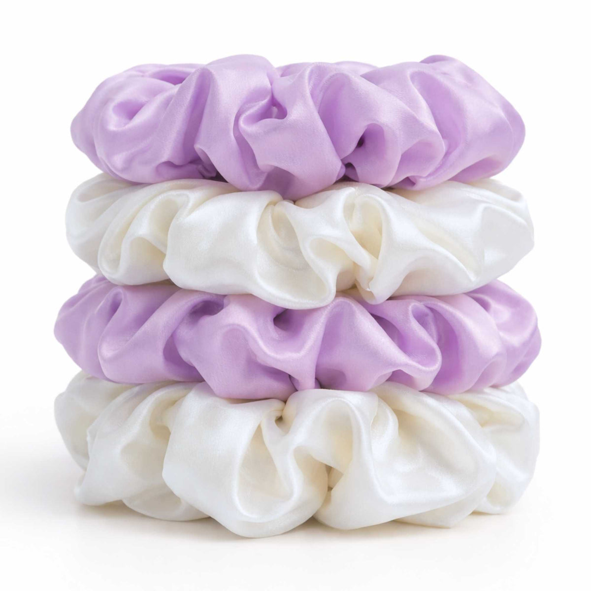 Stack of purple and white mulberry silk scrunchies on a white background