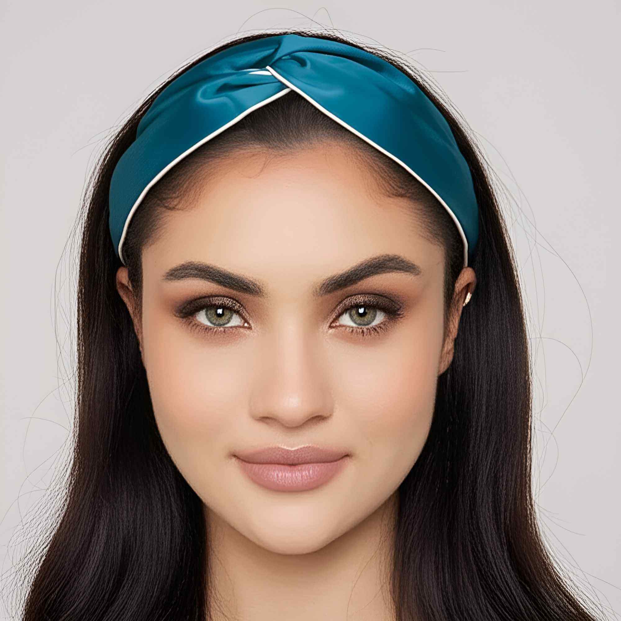 Woman wearing a teal blue silk headband with a plain background