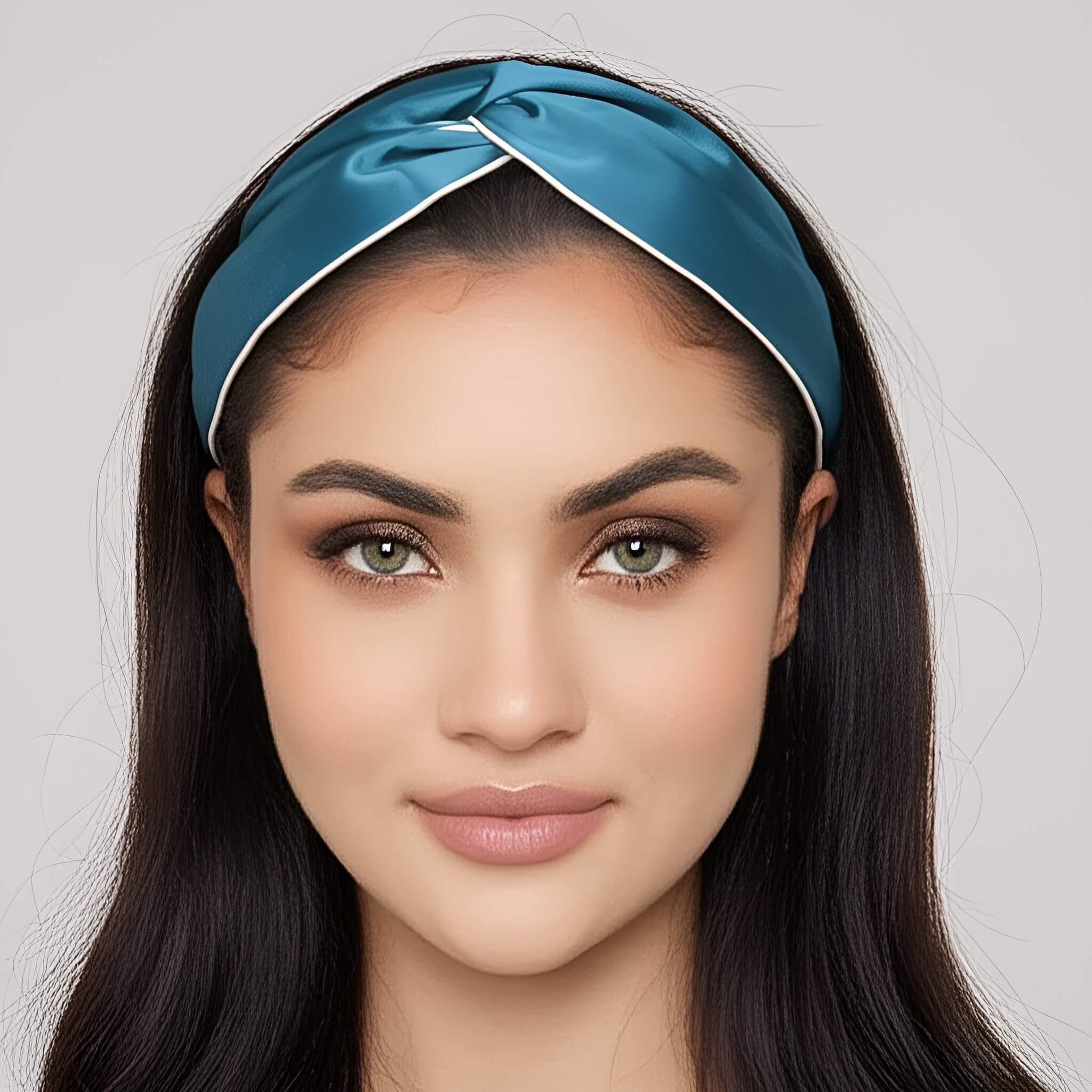 Woman wearing a blue silk headband with a plain background