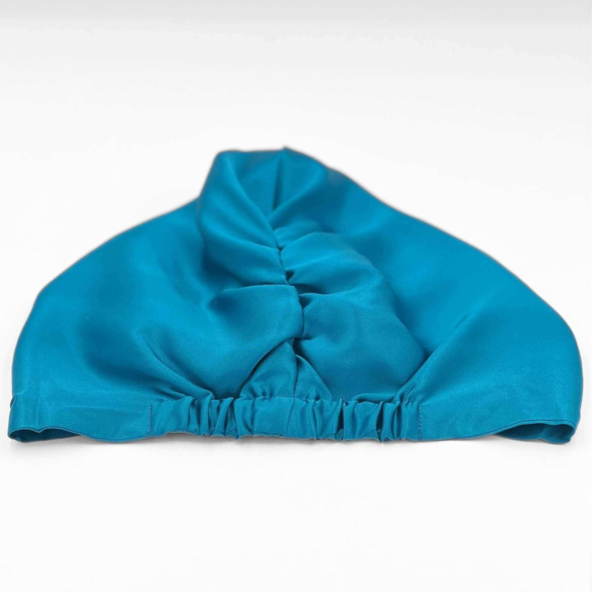 Back view of a teal silk bonnet laying flat