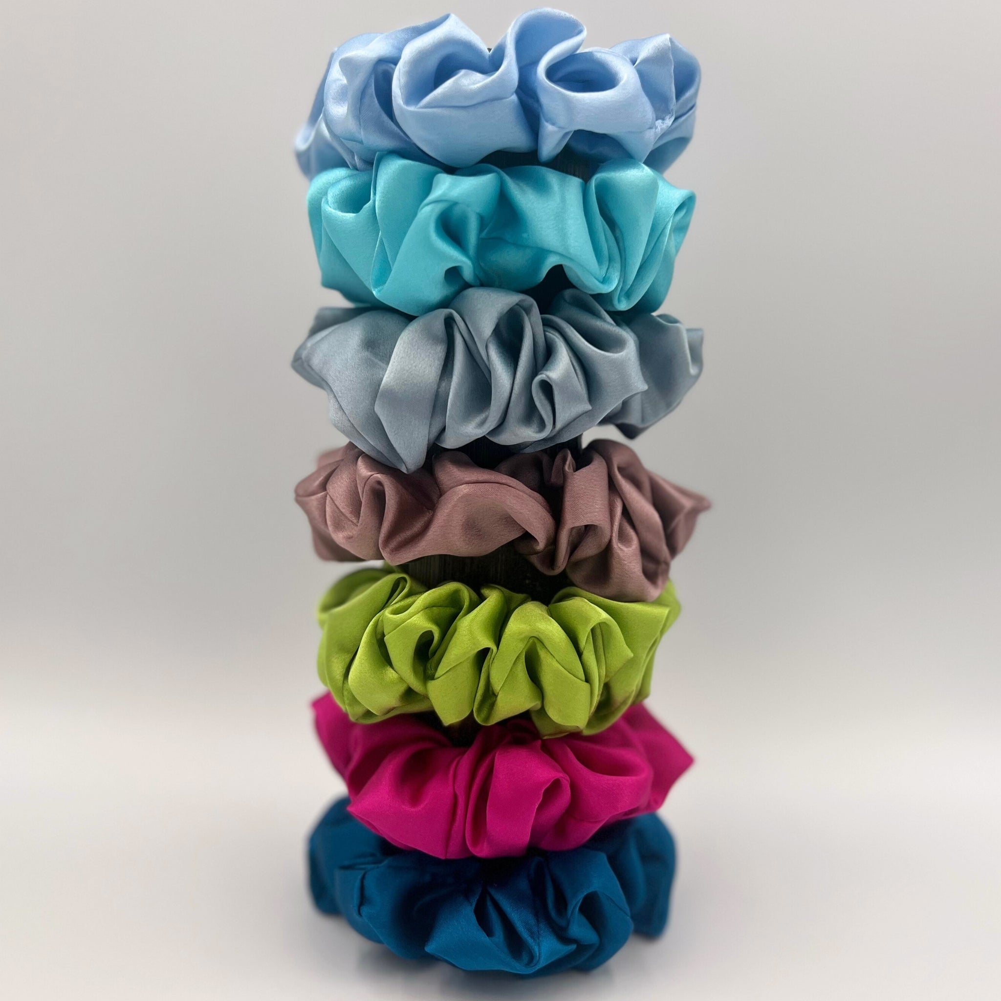 ‘Dusky Pink’, 'Bright Pink', 'Lime Green' ,'Baby Blue', 'Crystal Teal', 'Robin's Egg Blue' and 'Dusty Blue' silk scrunchies stacked