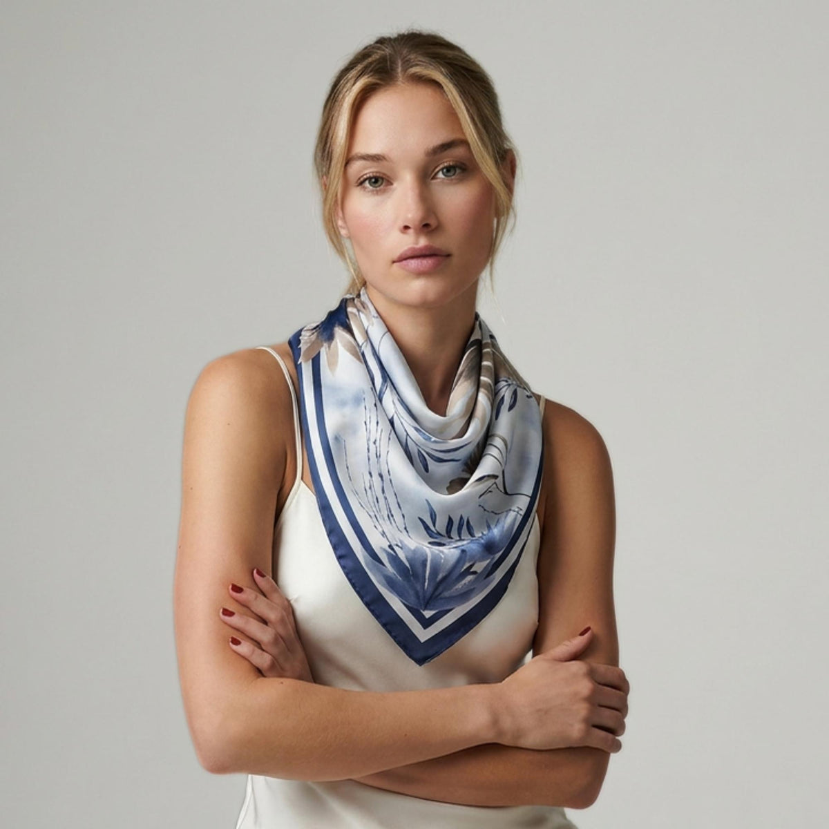 Woman wearing a beautiful botanicals silk twill scarf on a plain background