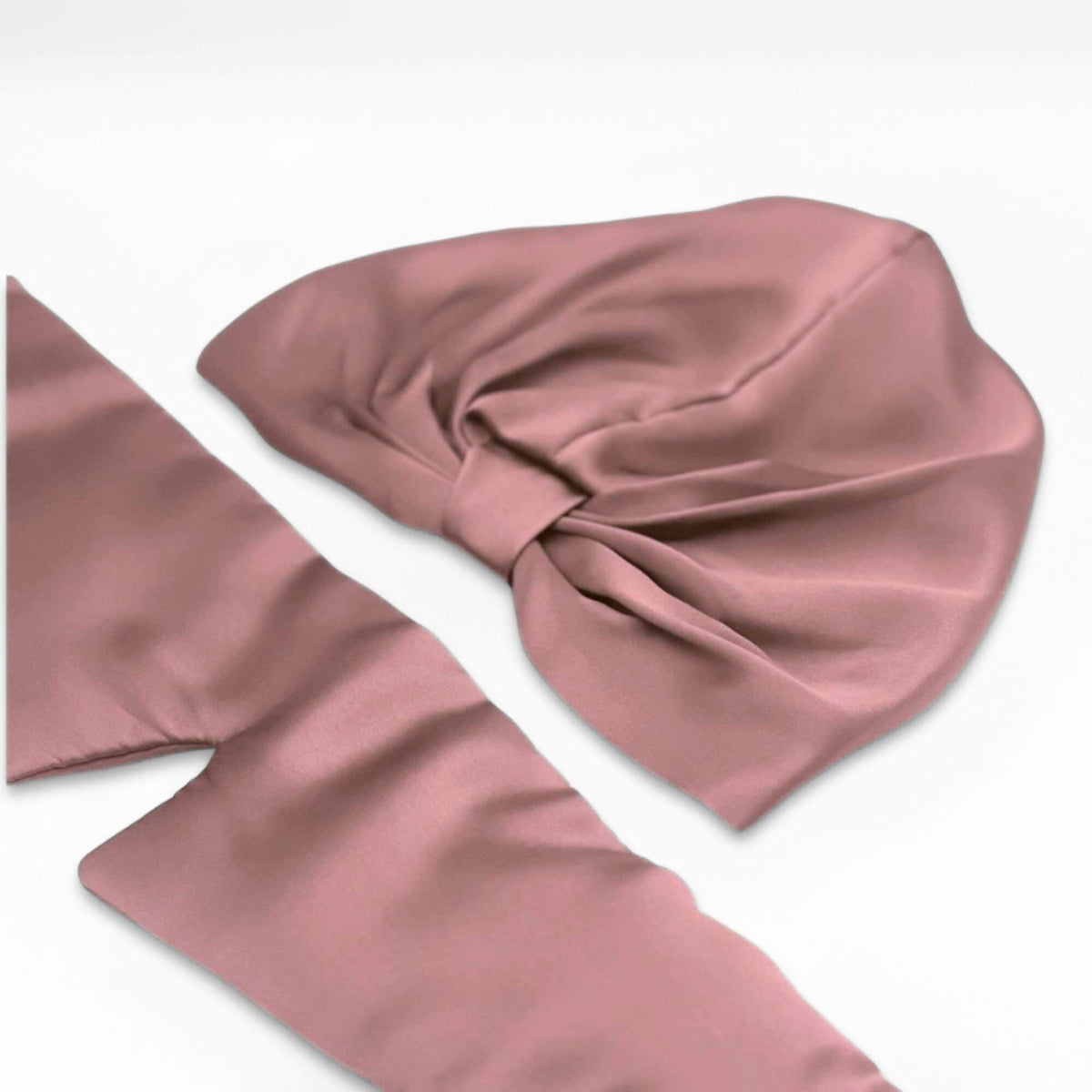 pink silk eye mask and bonnet on a white background
