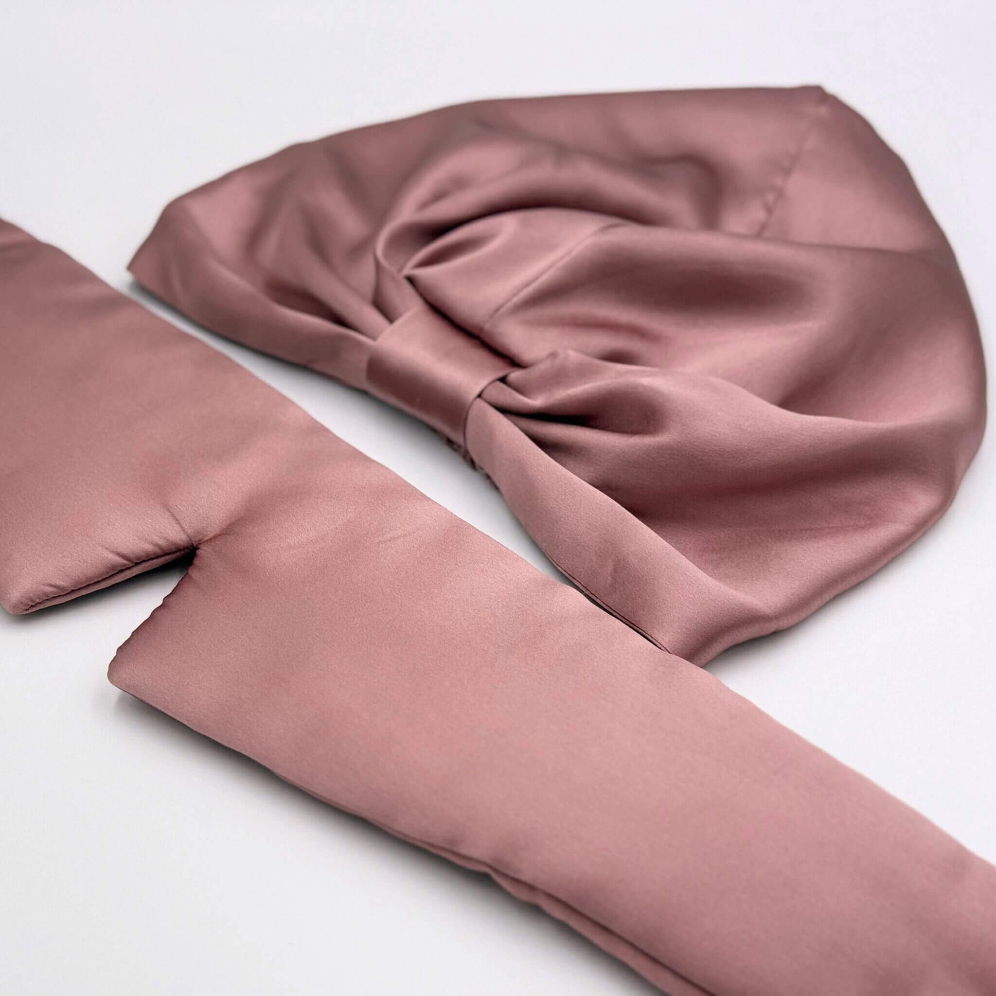 pink silk eye mask and bonnet on a white background