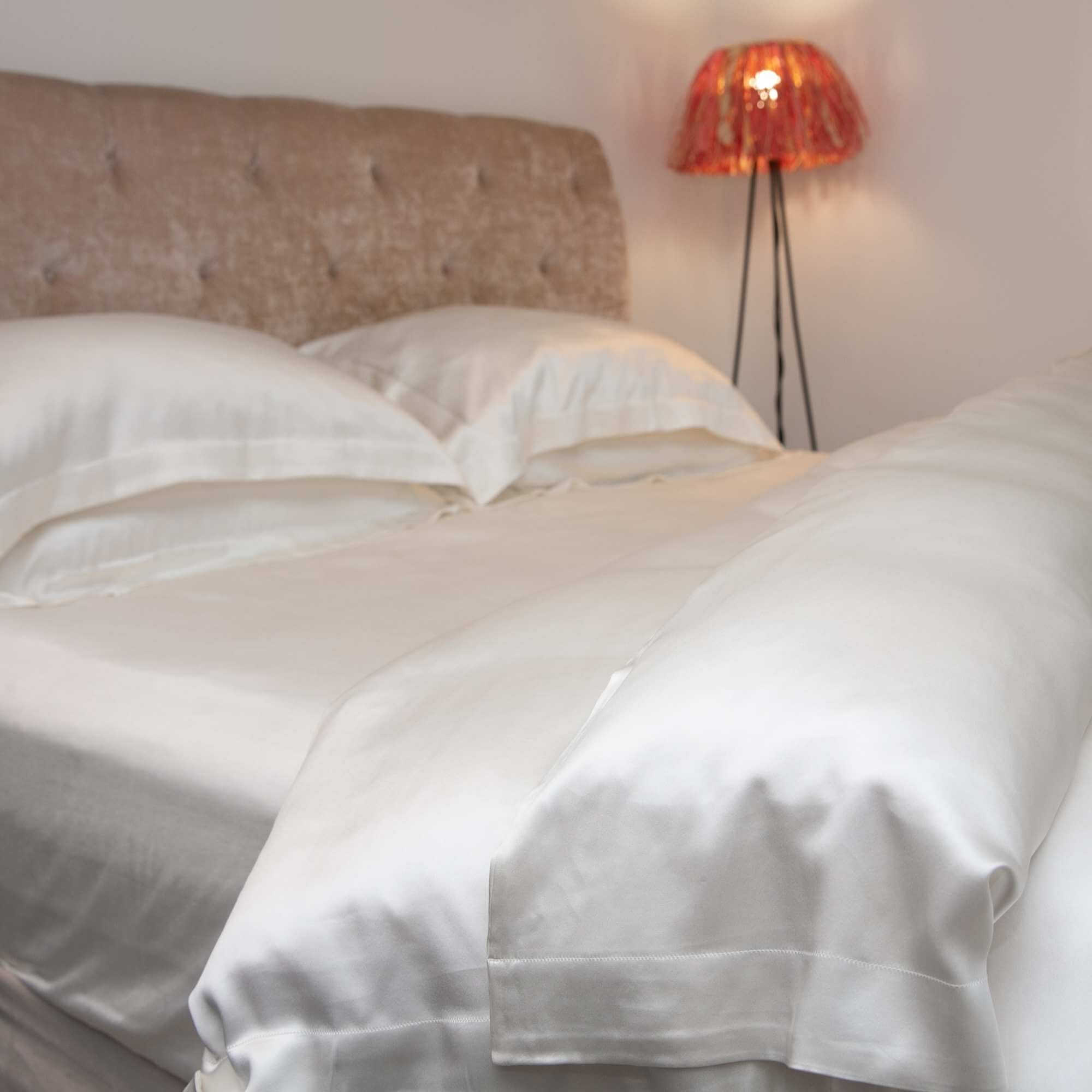 ivory 25 momme silk bed set with the duvet corner folded back, closeup