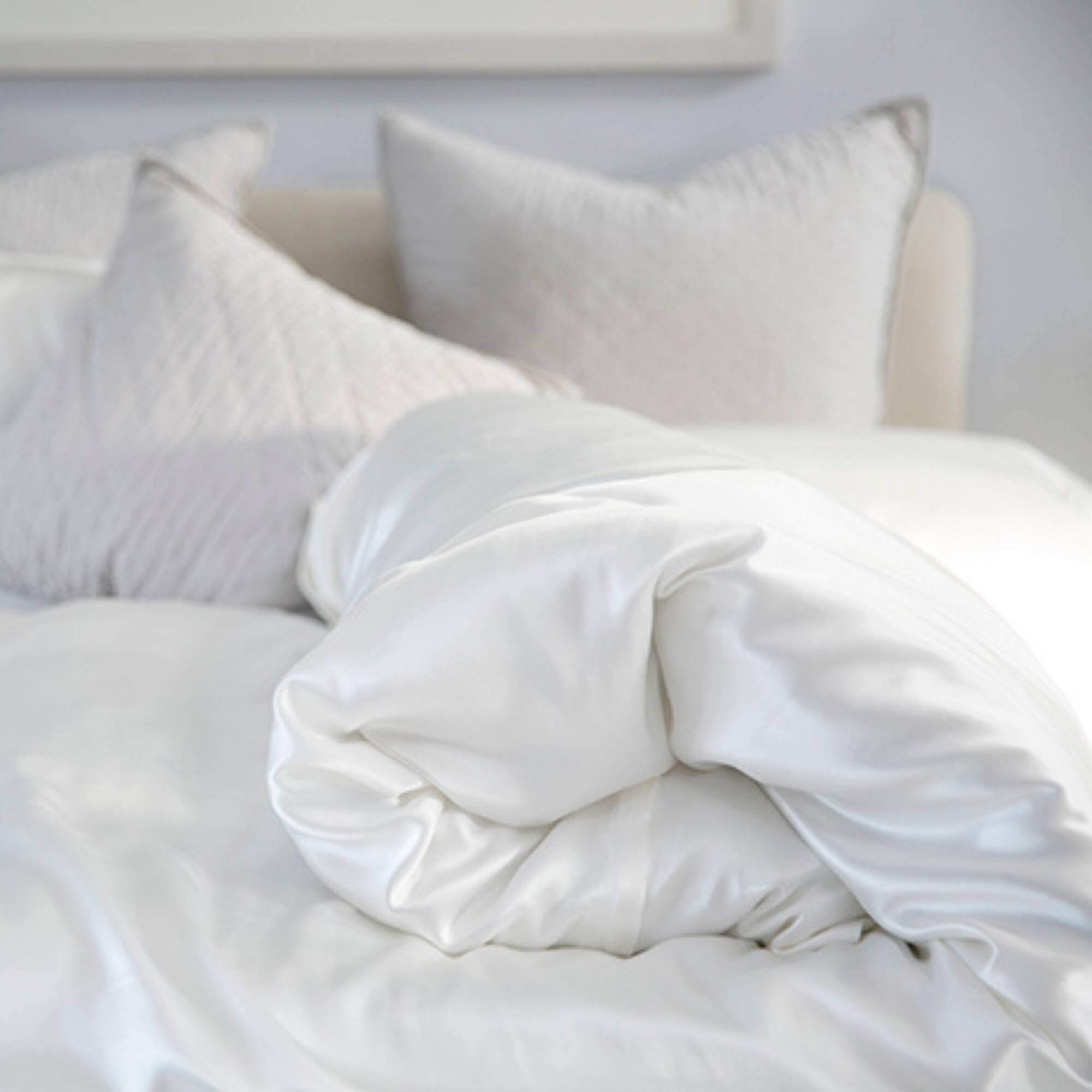 close up of a ivory 25 momme silk duvet cover on a silk bed set