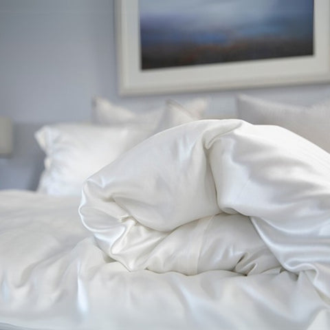 close up of a ivory 25 momme silk duvet cover on a silk bed set