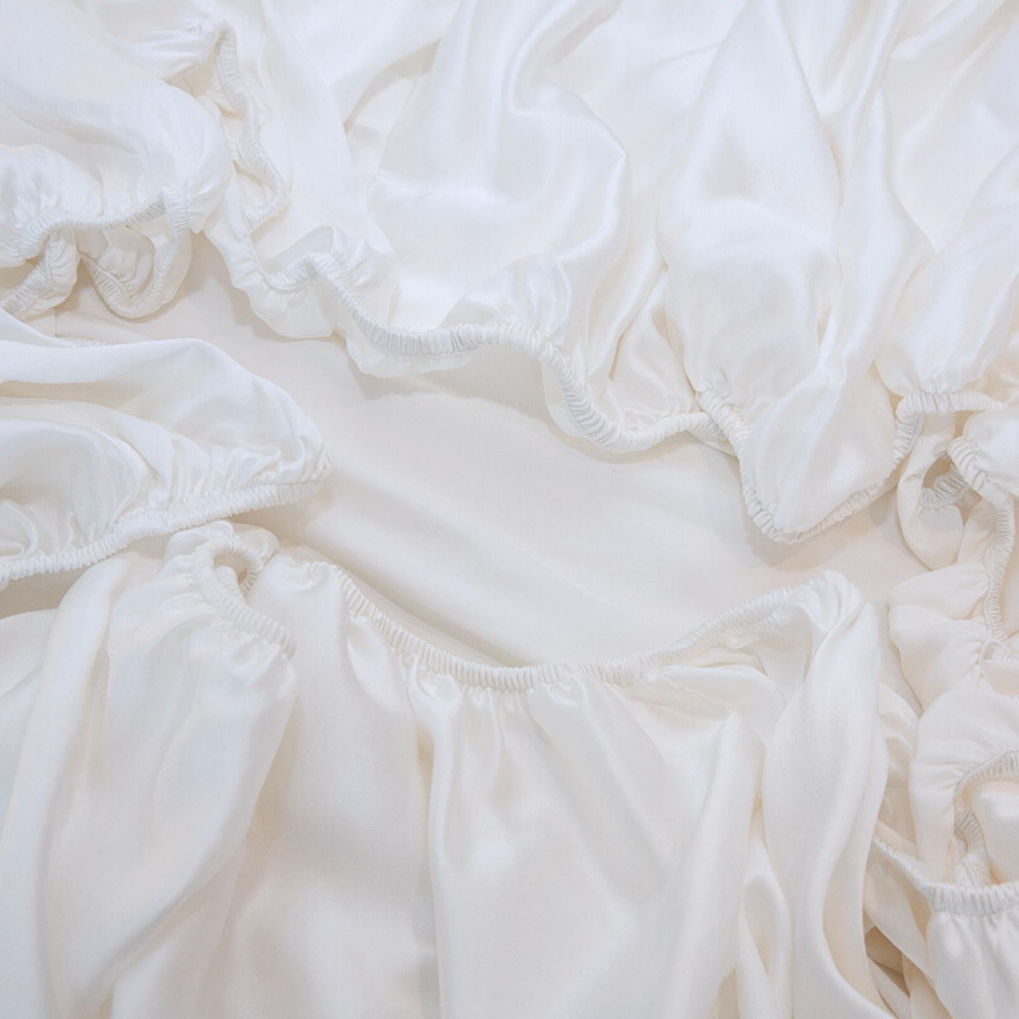 Close-up of white silk fitted sheet elastic