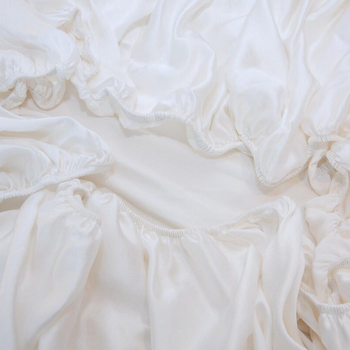Close-up of white silk fitted sheet elastic