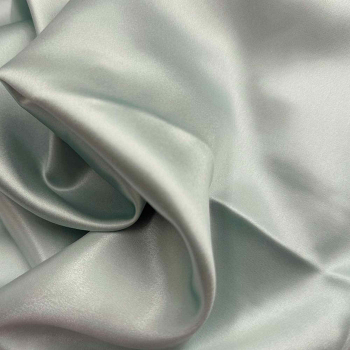 Close-up of glacial green silk fabric with folds