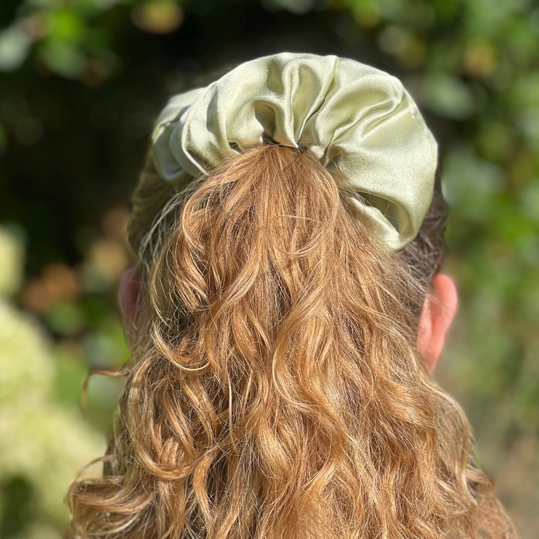 pistachio green oversized silk scrunchie in a high ponytail rear angle