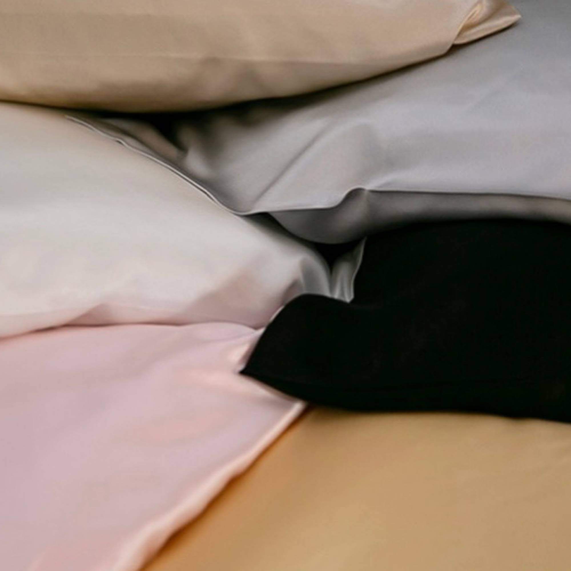The corner of (clockwise) champagne, silver, black, gold, pink and ivory silk pillowcases