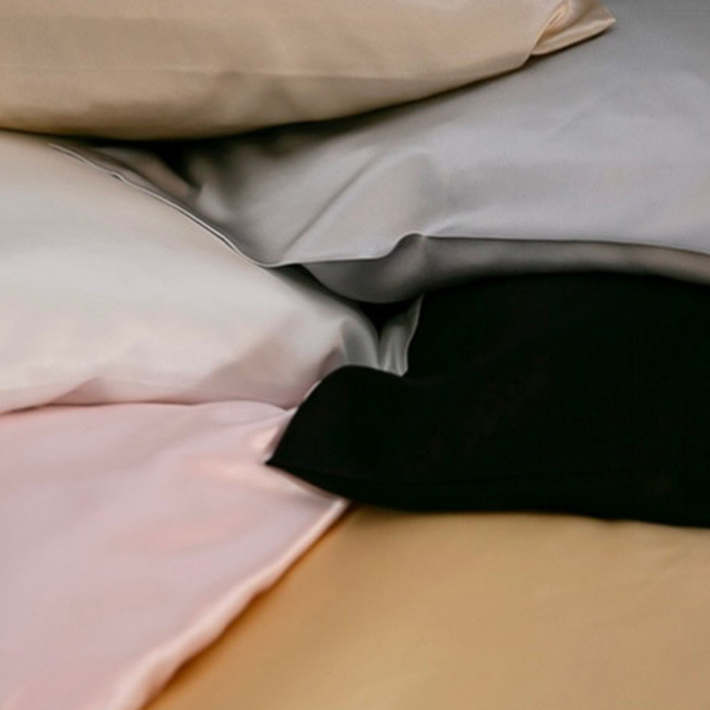 The corner of (clockwise) champagne, silver, black, gold, pink and ivory silk pillowcases