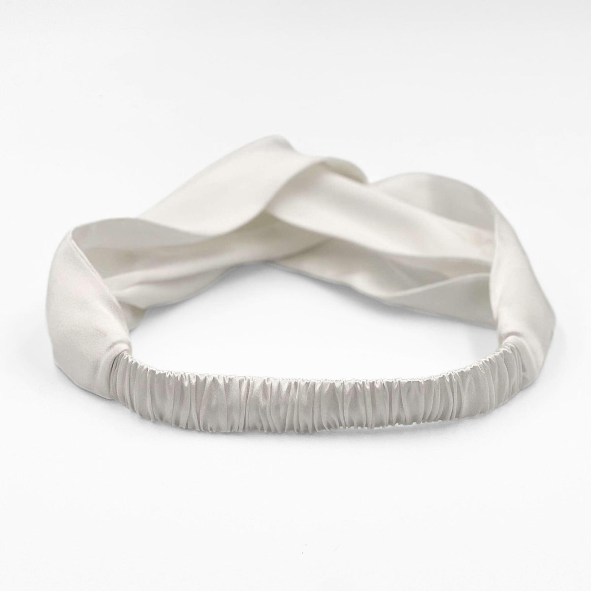 the elasticated back of the ivory white mulberry silk headband on a white background