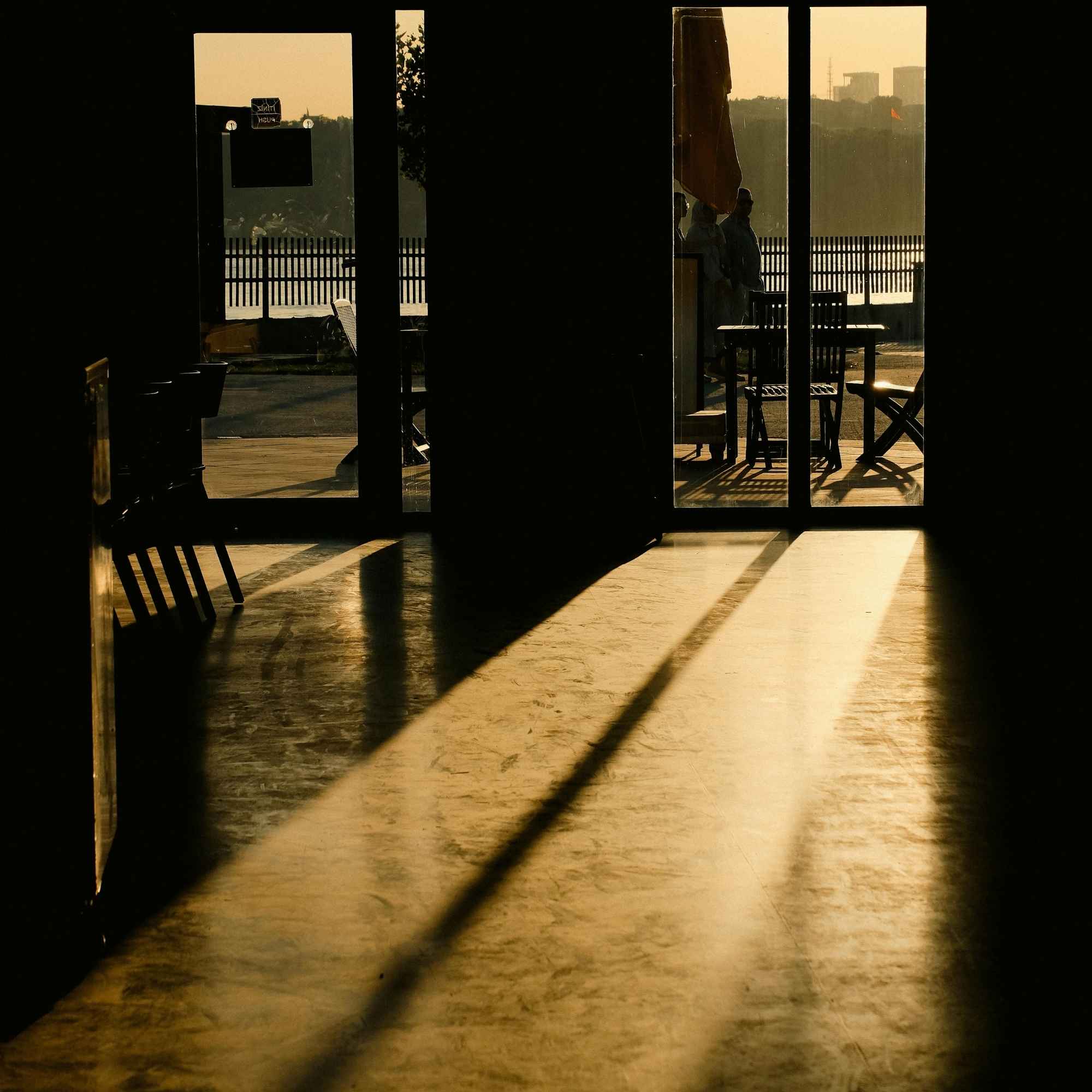 Sunlight streaming through large glass doors onto a wooden floor
