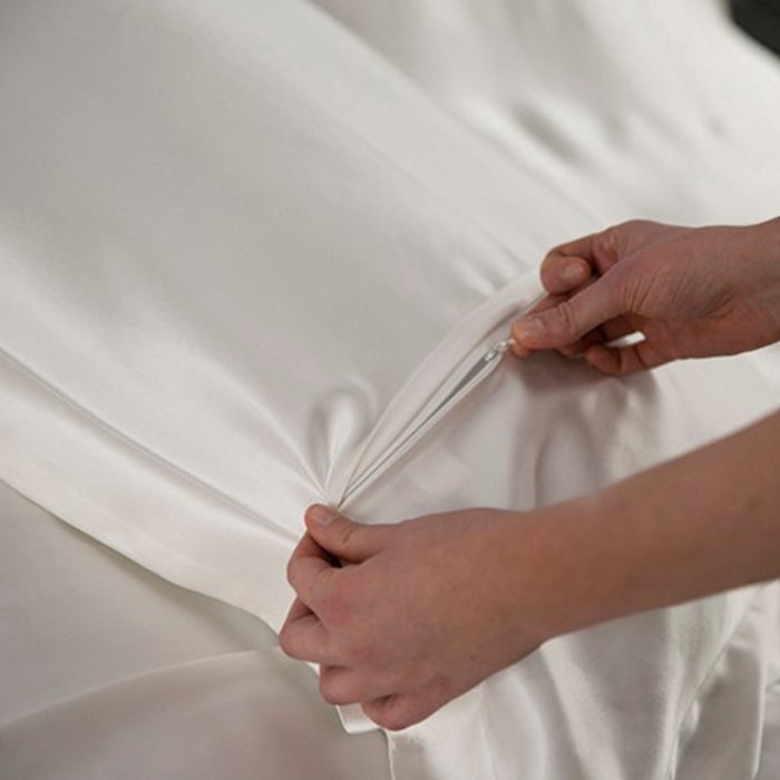 the concealed zip of an ivory silk oxford pillowcase