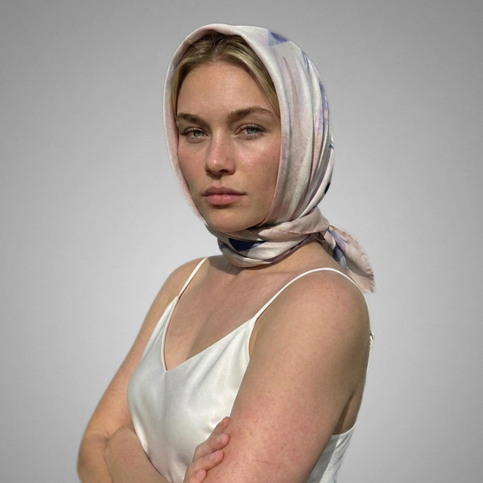 a woman wearing a petals and palms silk twill scarf tied around her head