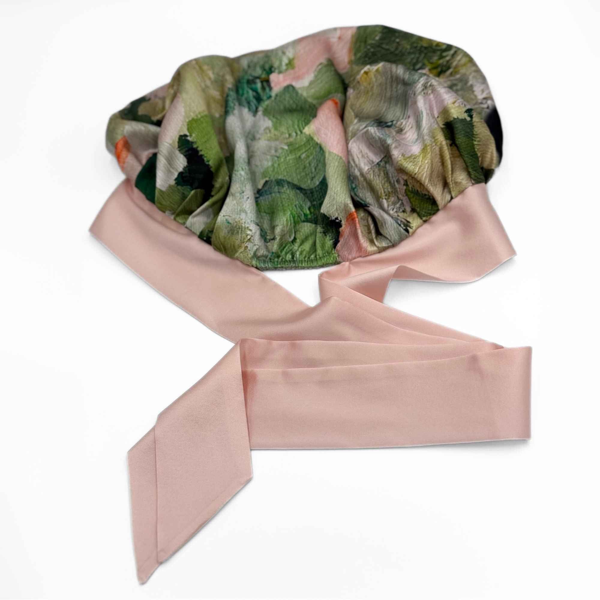 Floral-patterned silk tie bonnet with a pink tie on a white background