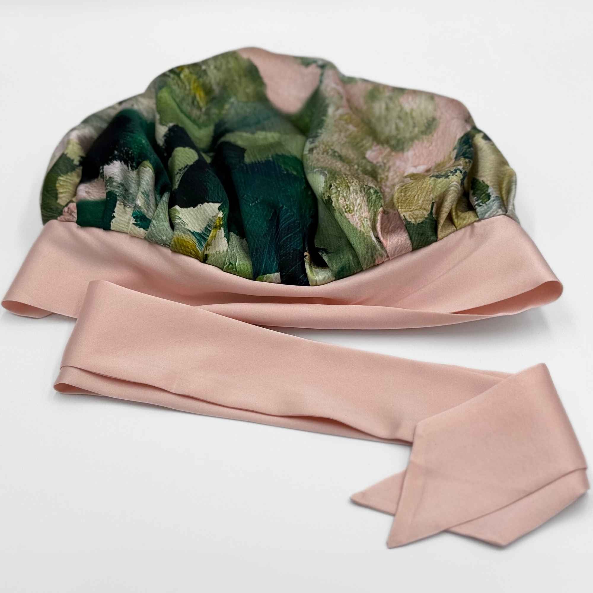 Floral-patterned silk bonnet with a pink tie on a white background