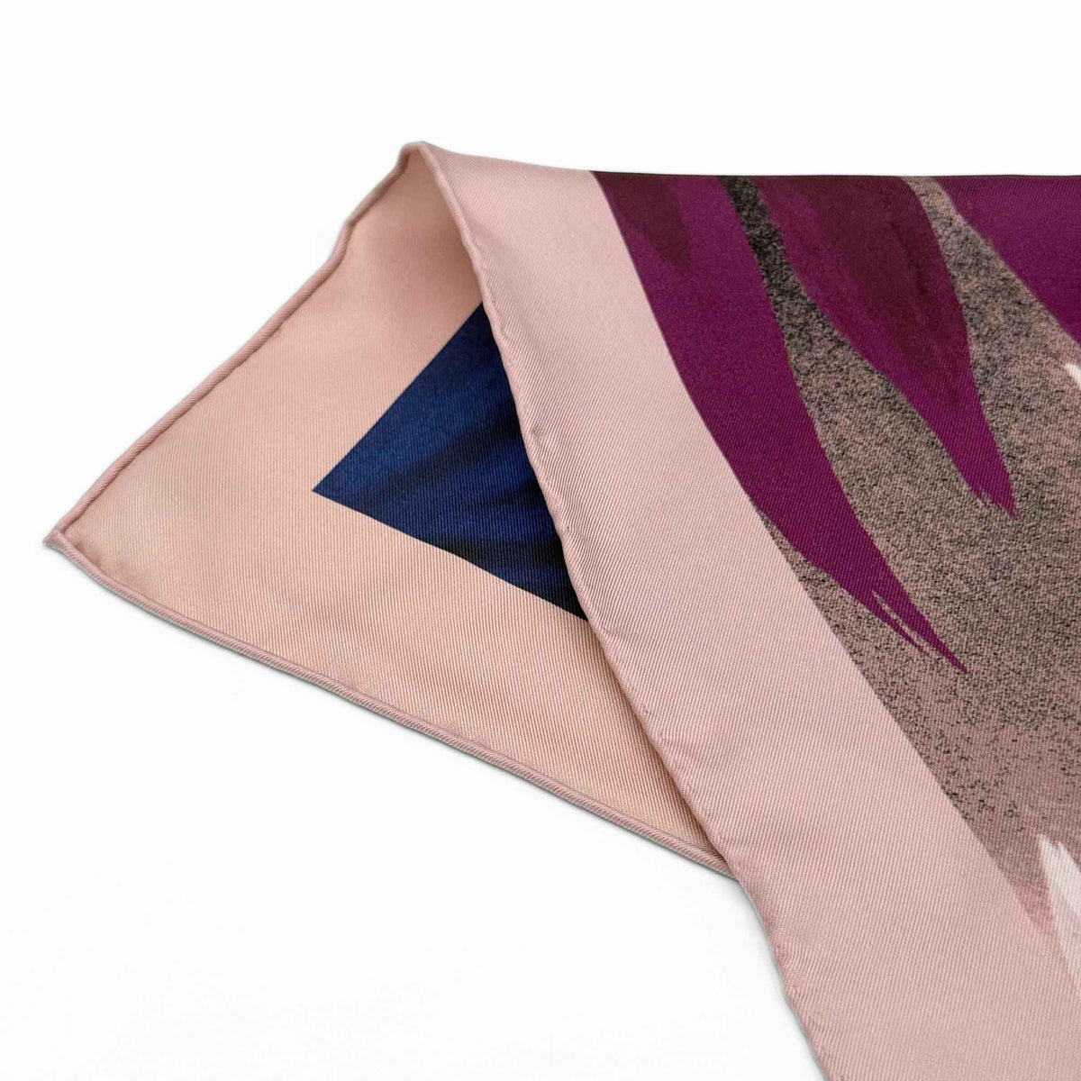 Close-up of a pink silk twill scarf with a floral pattern on a white background