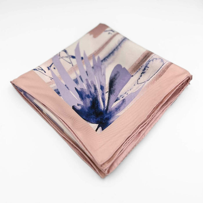 Folded silk twill scarf with abstract design on a white background