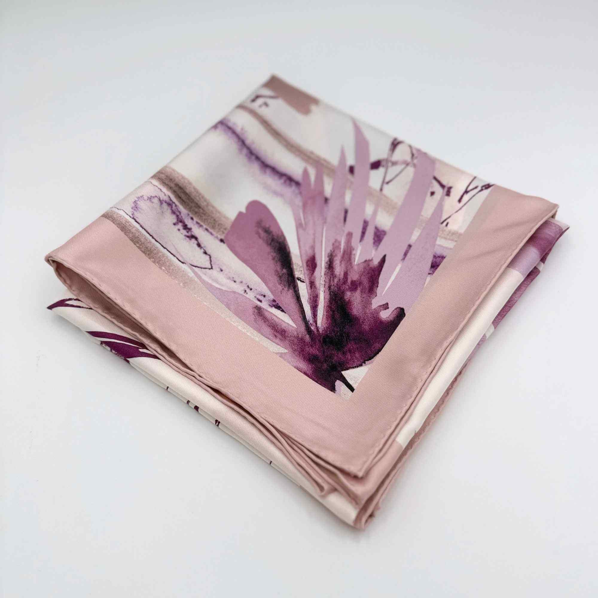 Folded silk twill scarf with floral pattern on a white background