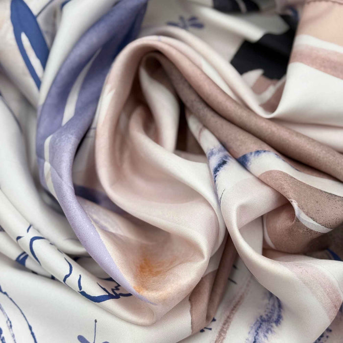 Close-up of a floral silk twill scarf fabric with blue and beige colours
