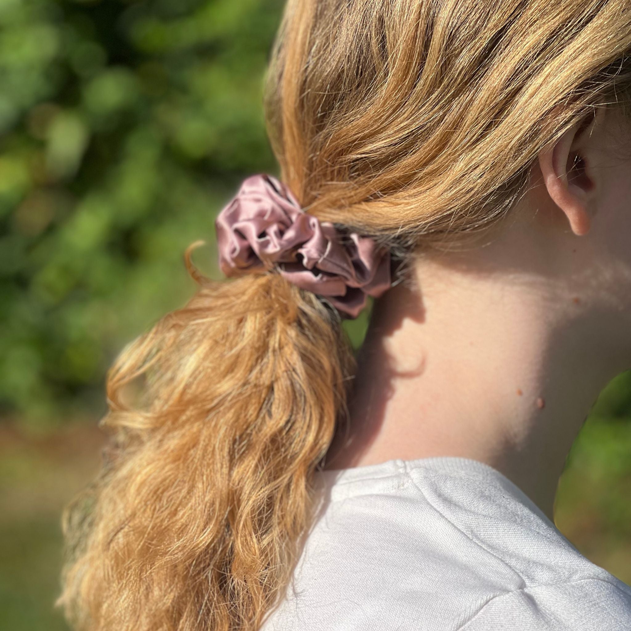 dusty pink silk scrunchie in a low ponytail