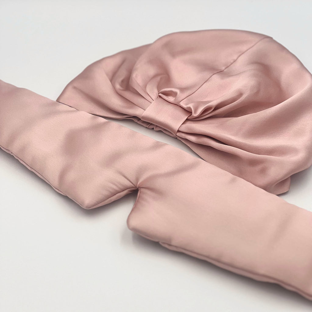 pink silk bonnet and eye mask set with the eye mask opened out to show its length