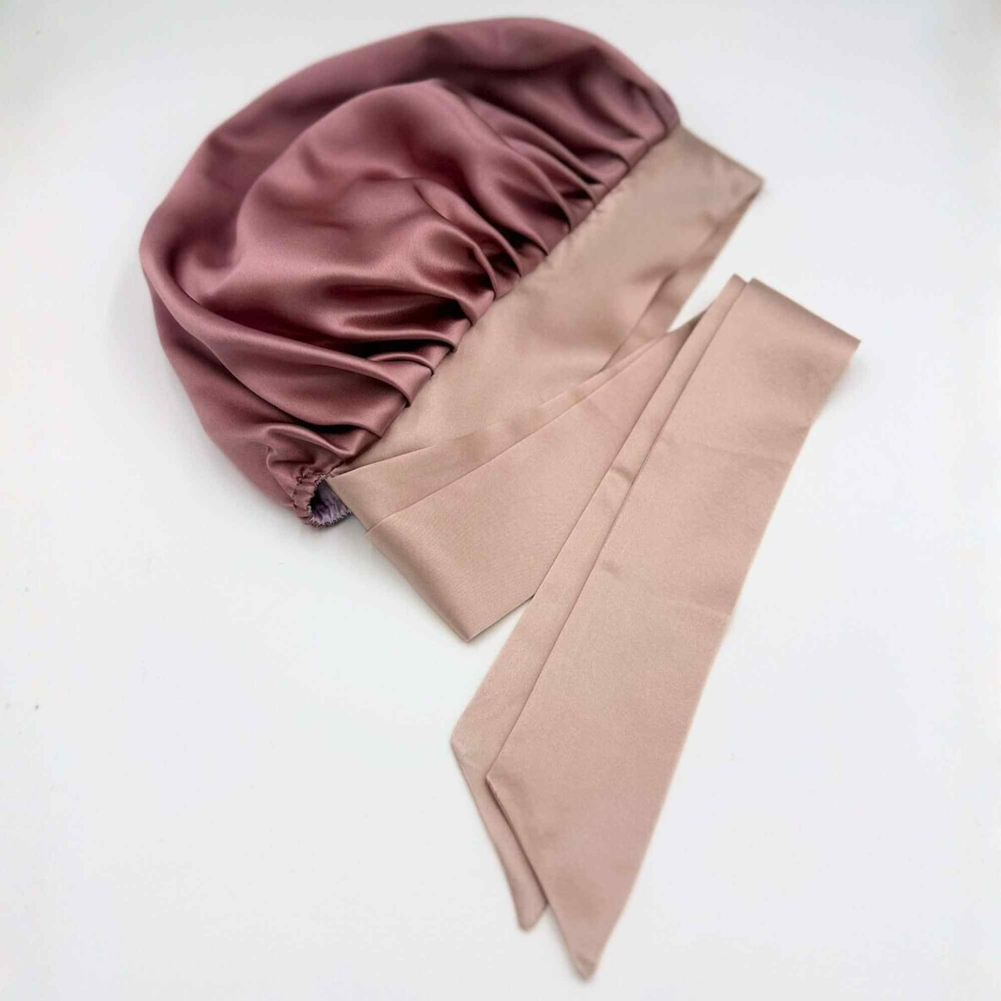 Pink mulberry silk bonnet with a matching pink silk tie on a white background
