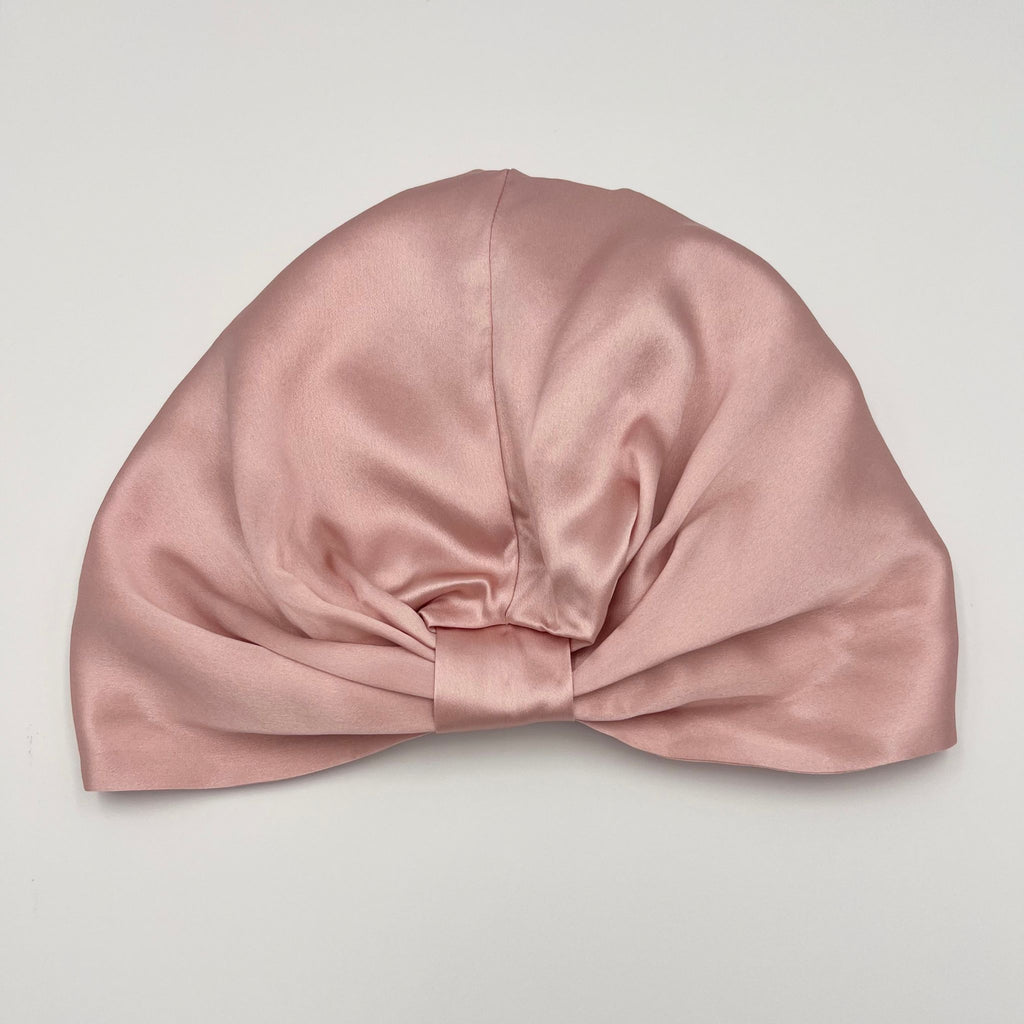 Pink silk bonnet laying flat