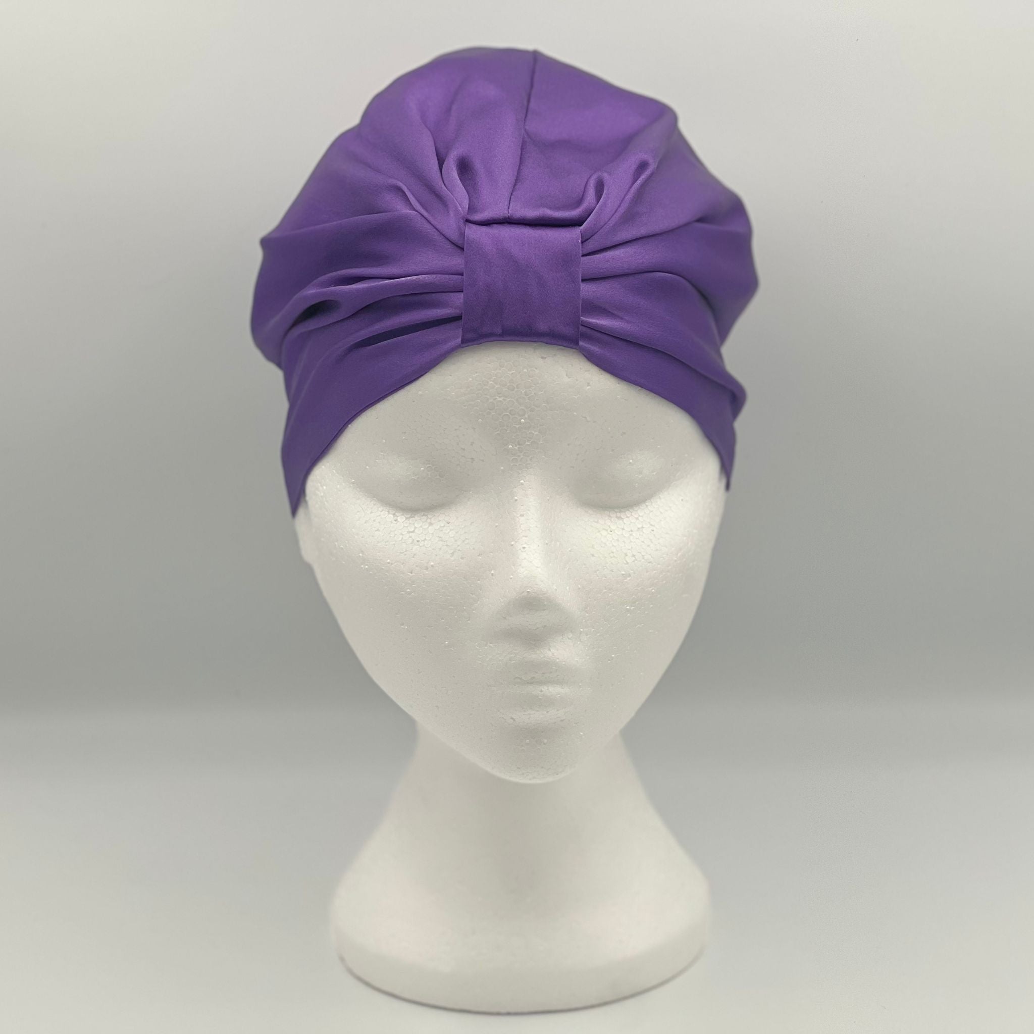 Front view of a purple silk bonnet on a mannequins head