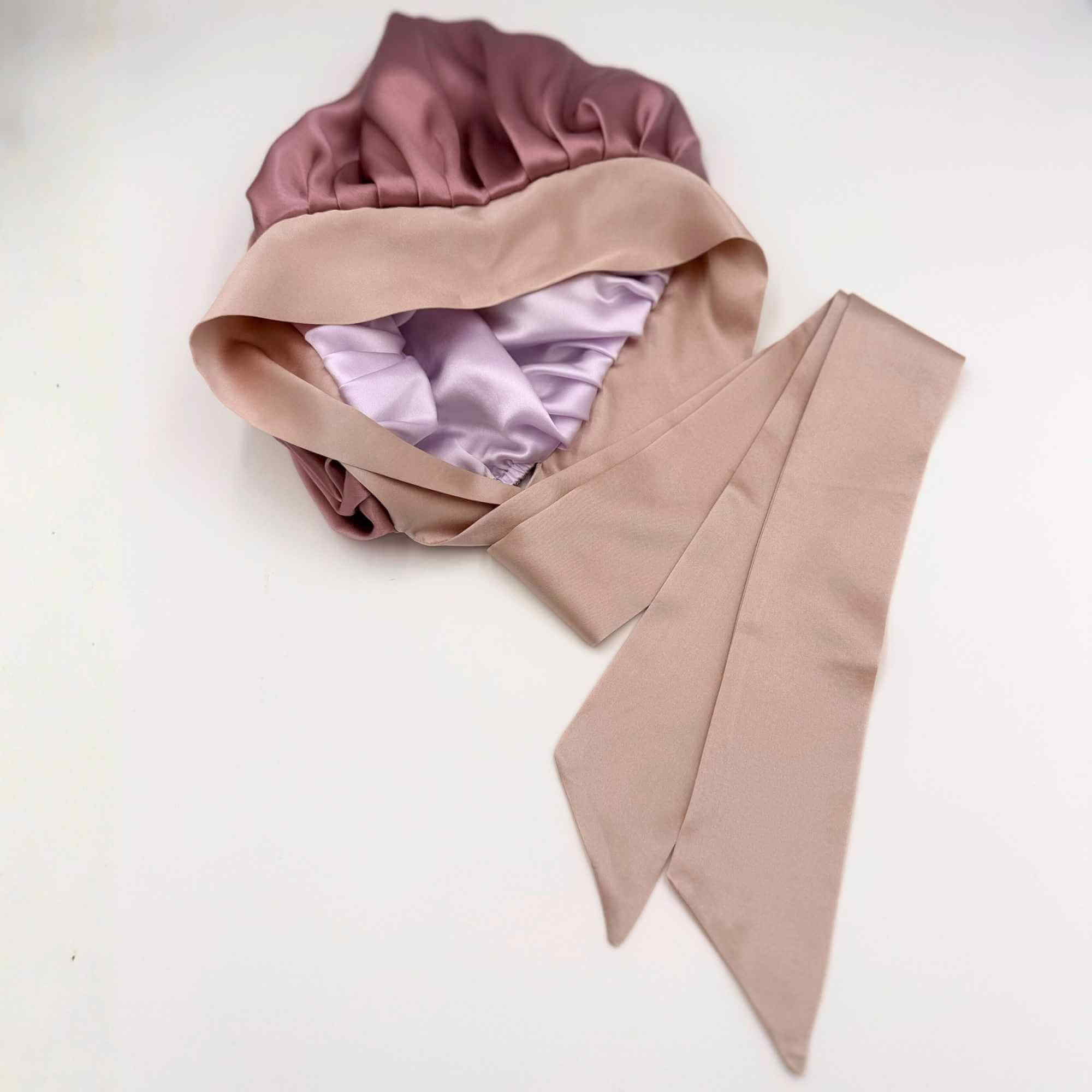 Pink and lavender silk hair bonnet on a white background